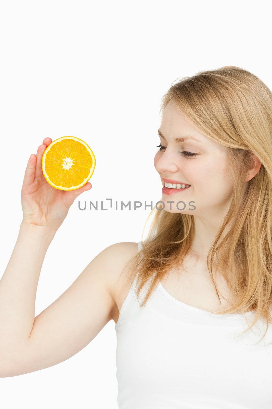 Joyful woman holding an orange against white background