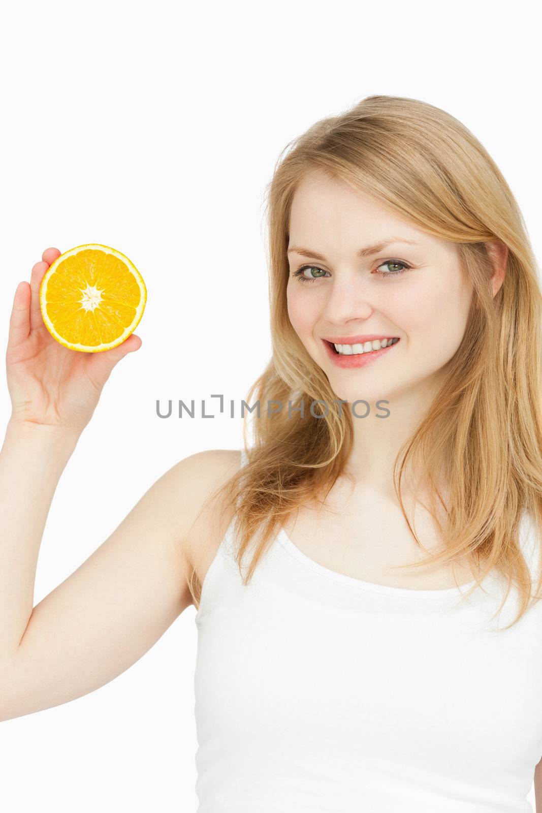 Smiling woman presenting an orange against white background