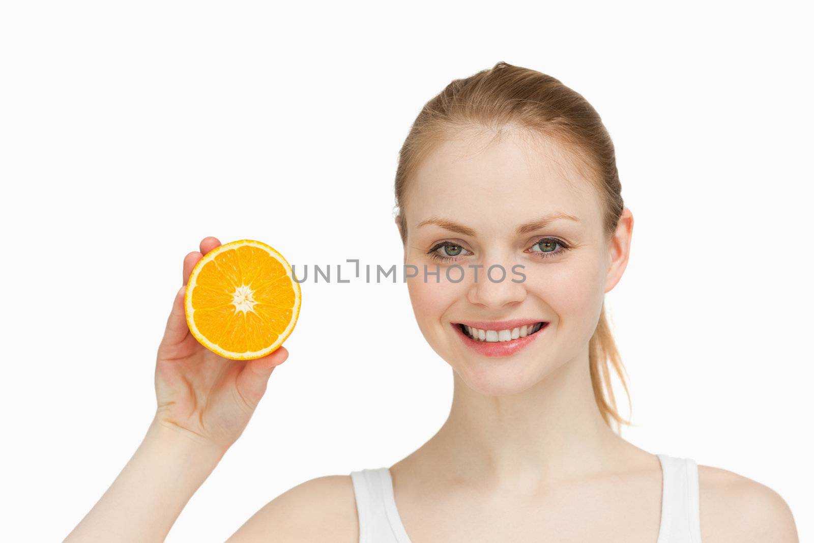 Cheerful woman presenting an orange by Wavebreakmedia