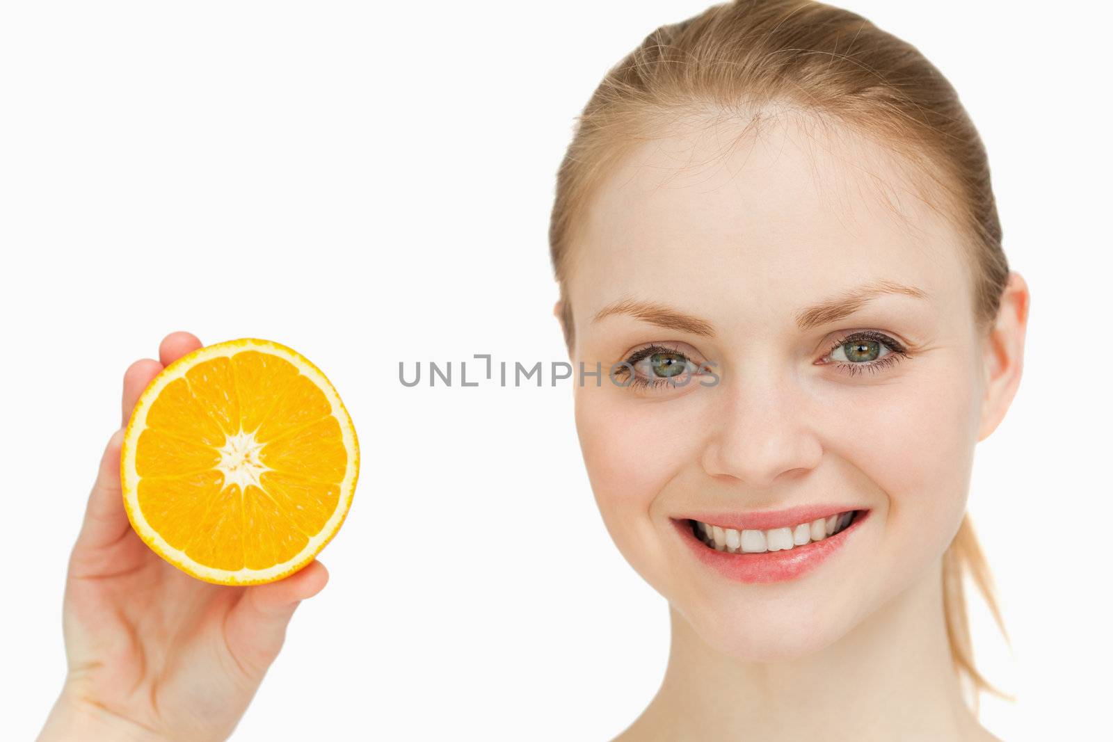 Close up of a cheerful woman presenting an orange by Wavebreakmedia