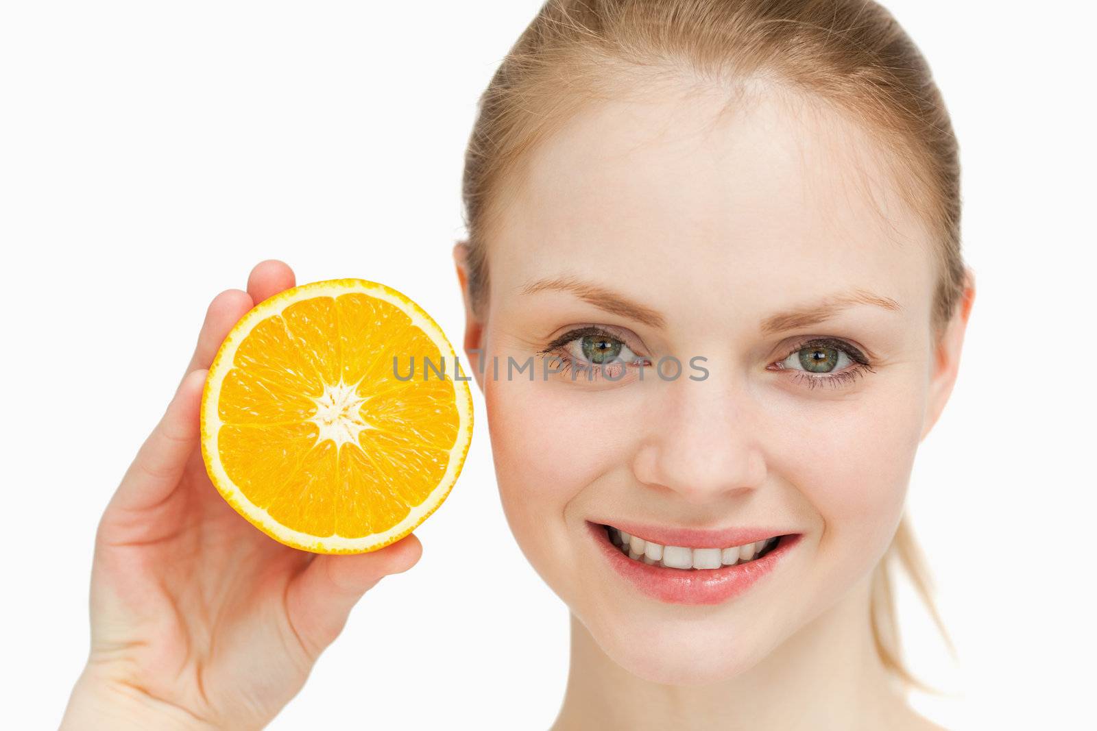 Close up of a smiling woman presenting an orange against white background