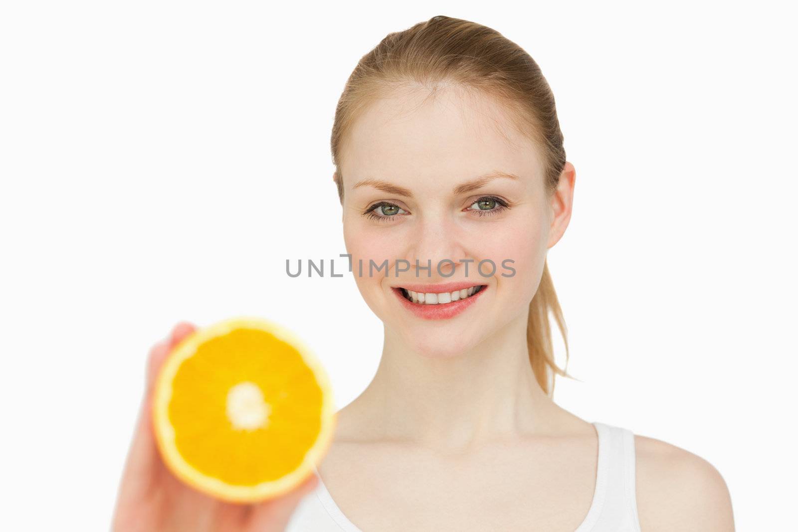 Woman presenting an orange while smiling by Wavebreakmedia
