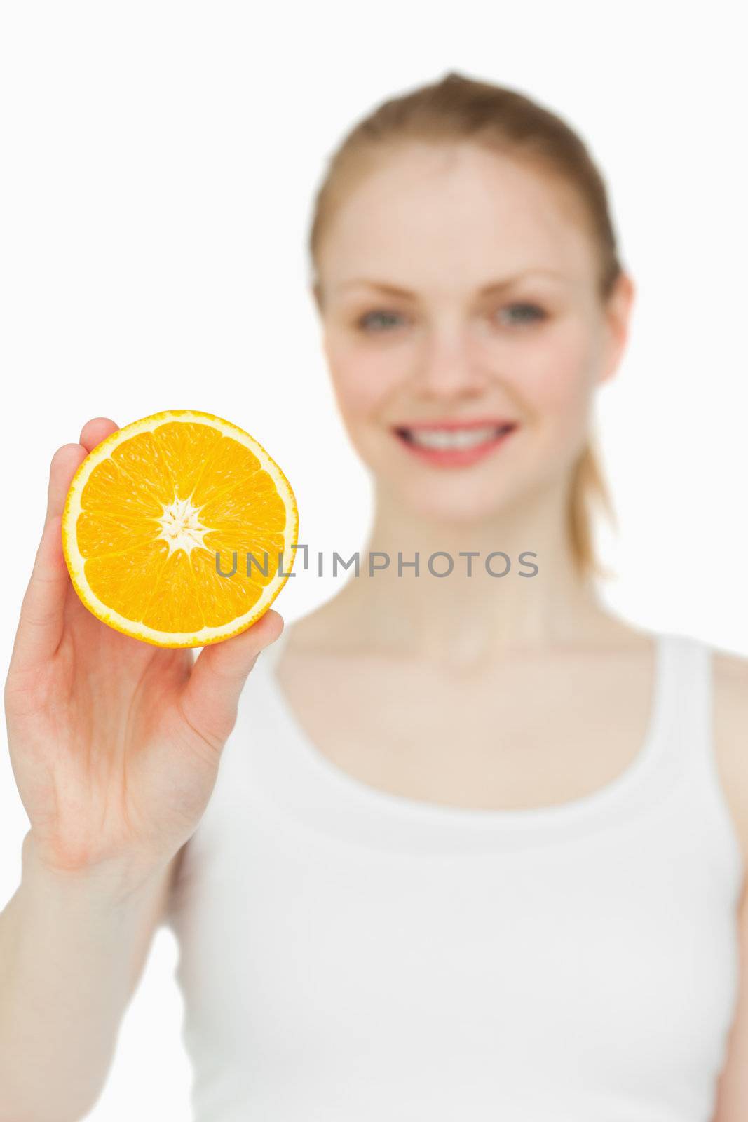Blonde-haired woman holding an orange against white background