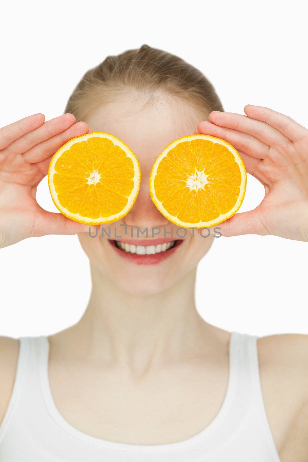 Close up of a woman placing oranges on her eyes by Wavebreakmedia