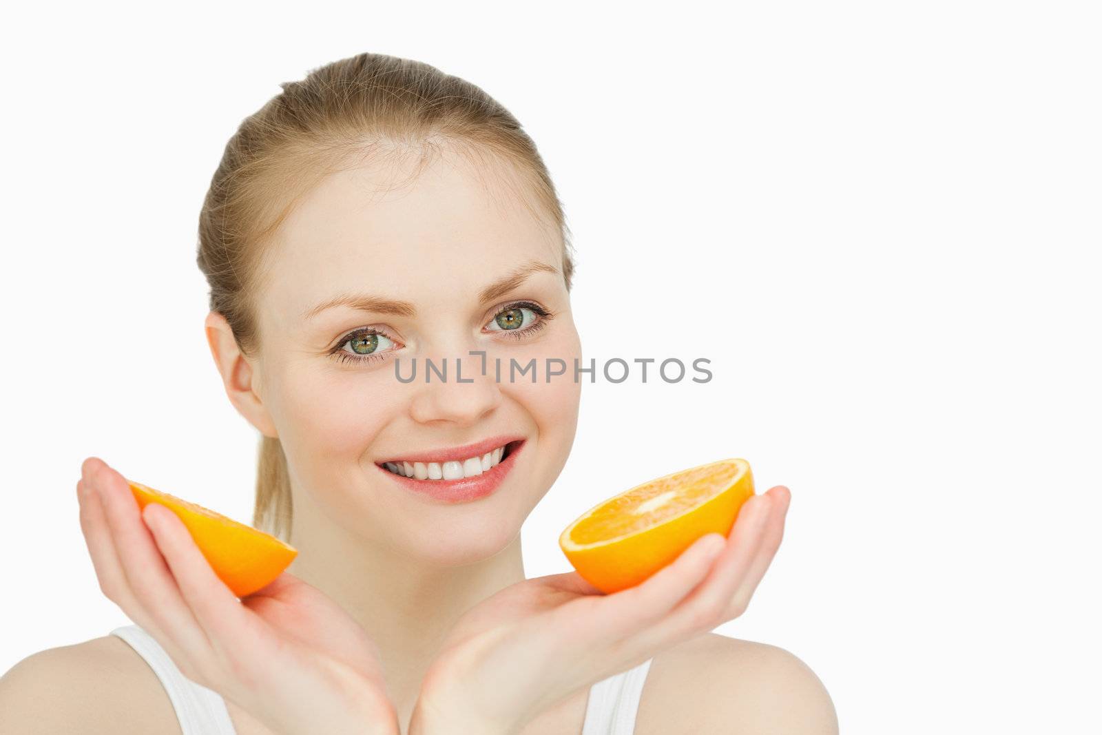 Smiling woman holding oranges against white background