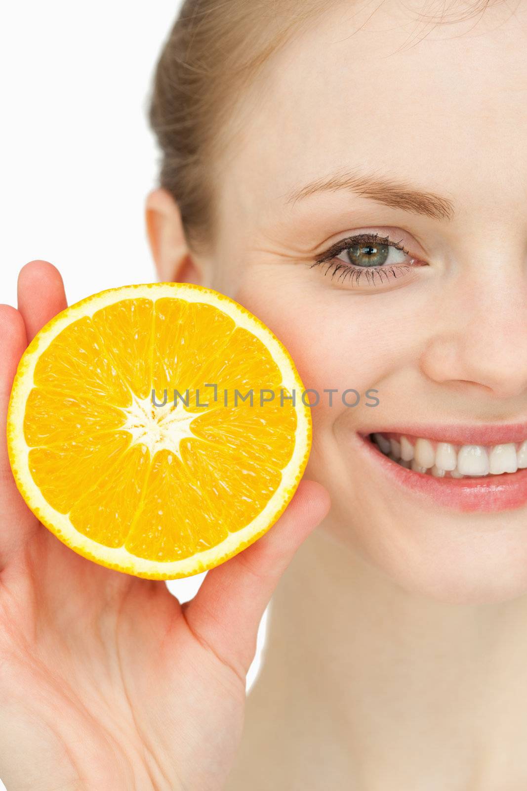 Close up of a smiling woman holding an orange against white background