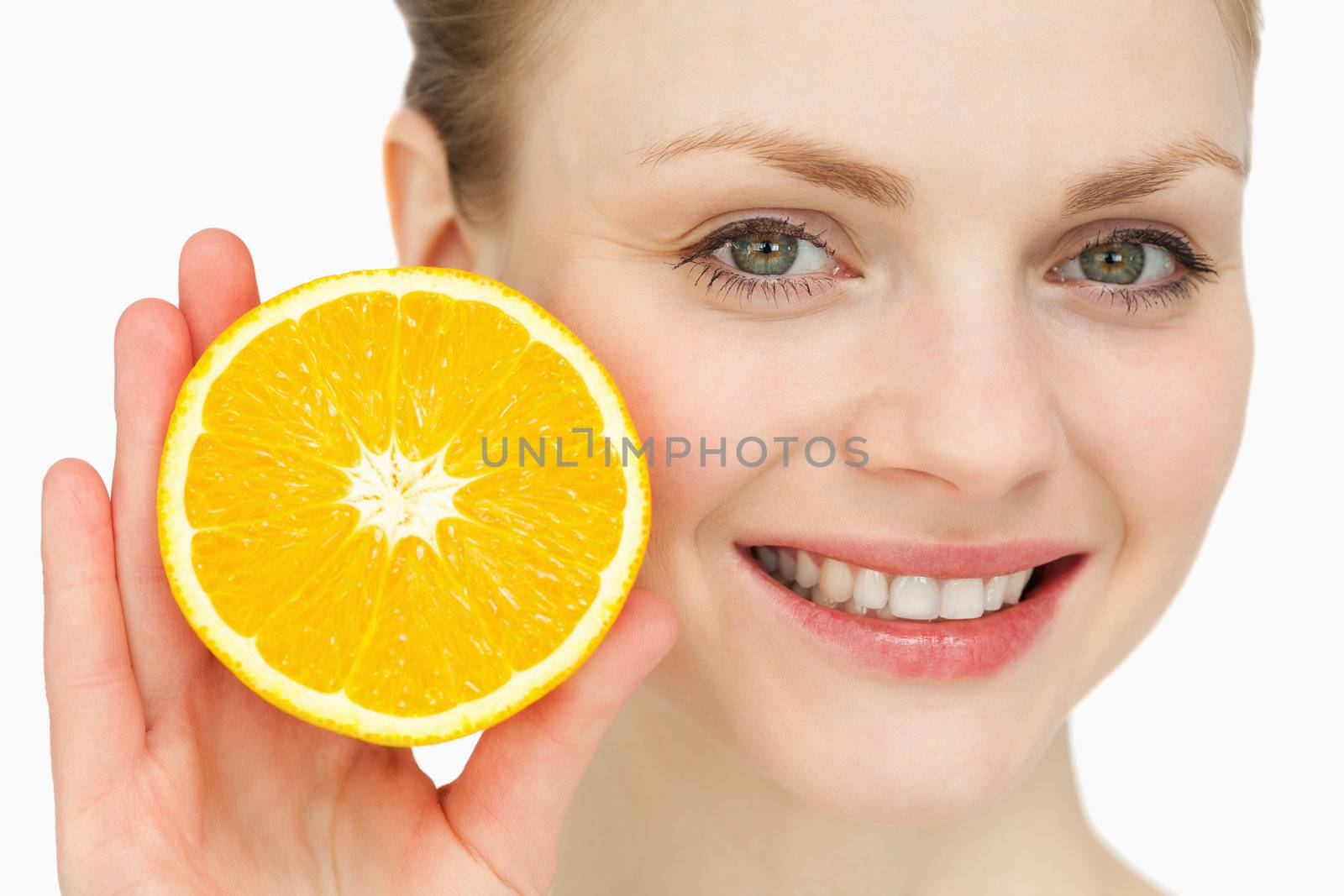 Blond-haired woman presenting an orange against white background