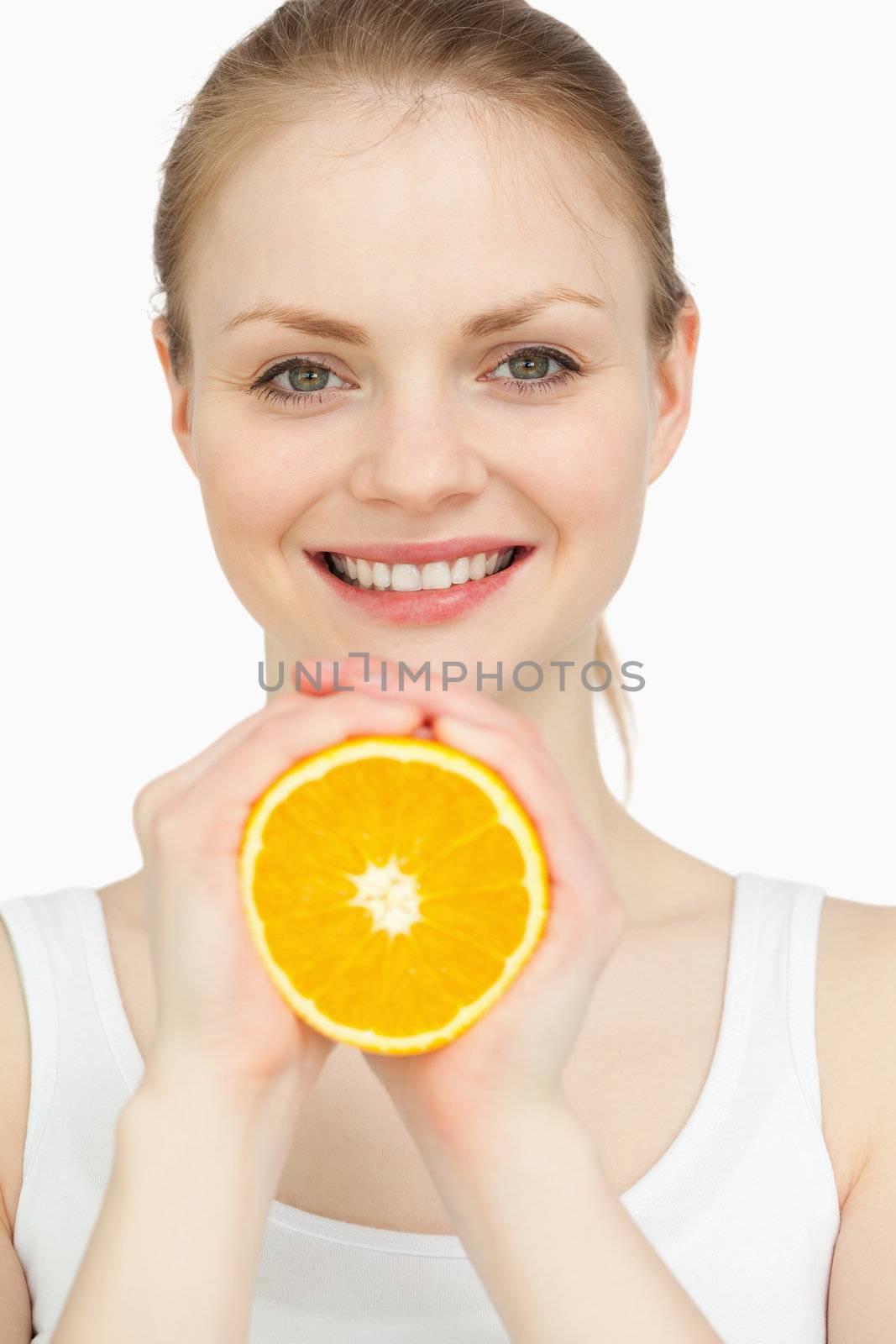 Smiling woman holding an orange in her hands by Wavebreakmedia
