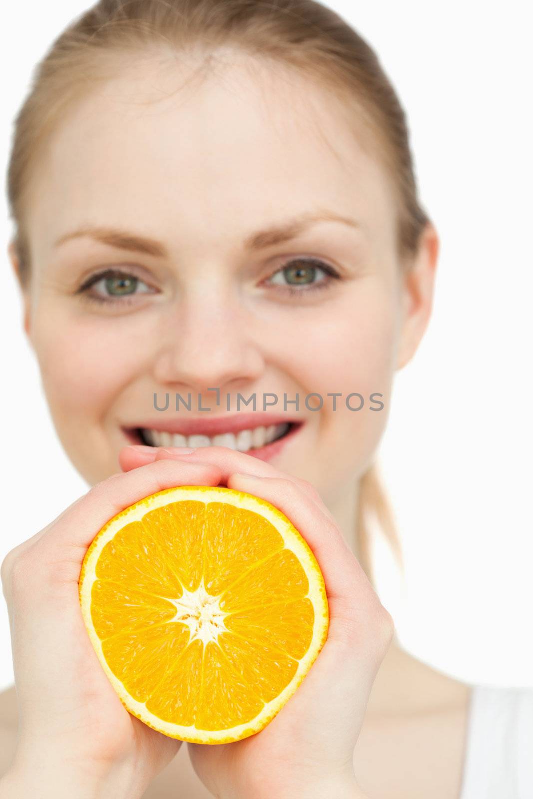 Close up of a woman squeezing an orange between her hands by Wavebreakmedia