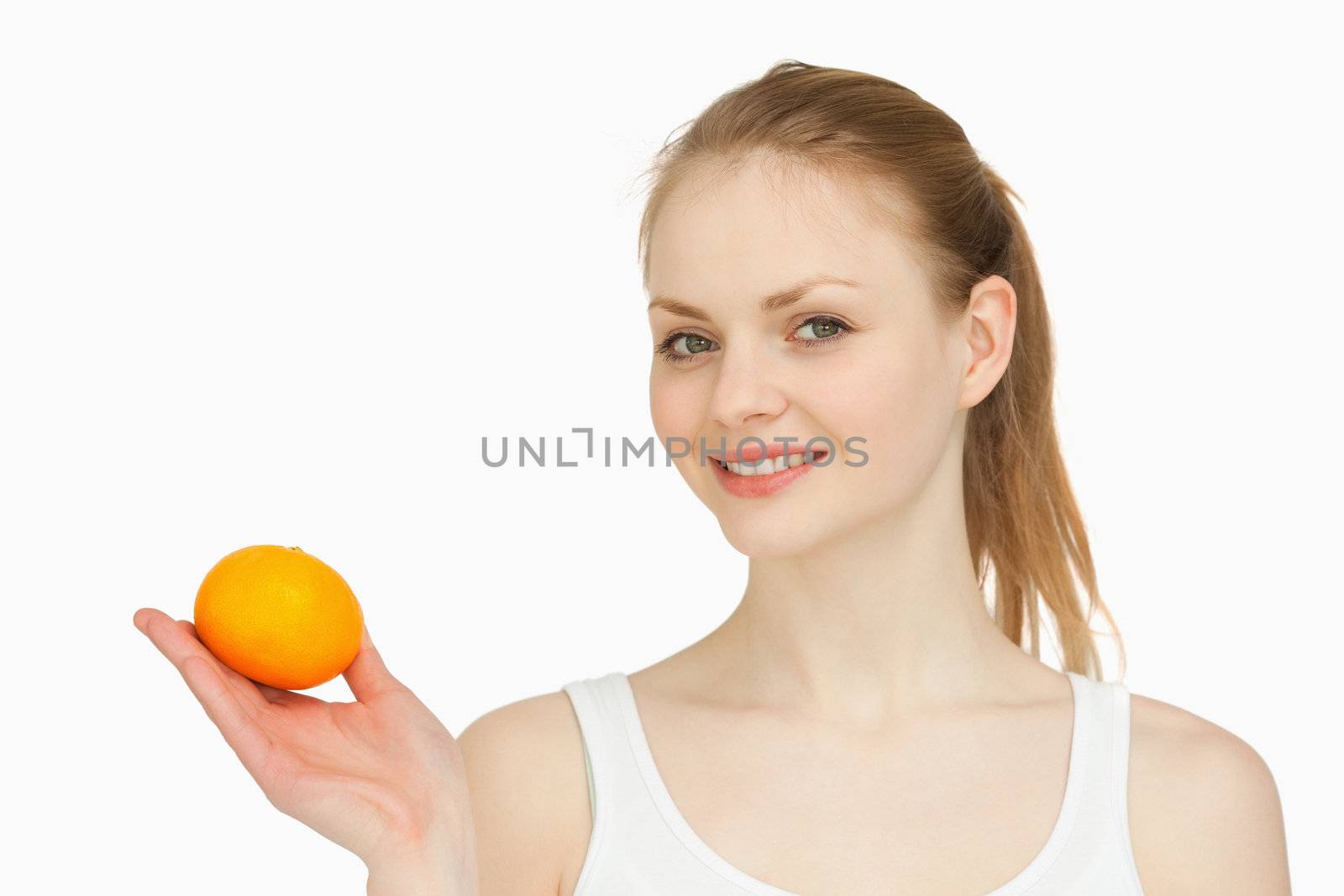 Woman holding a tangerine in her hand against white background