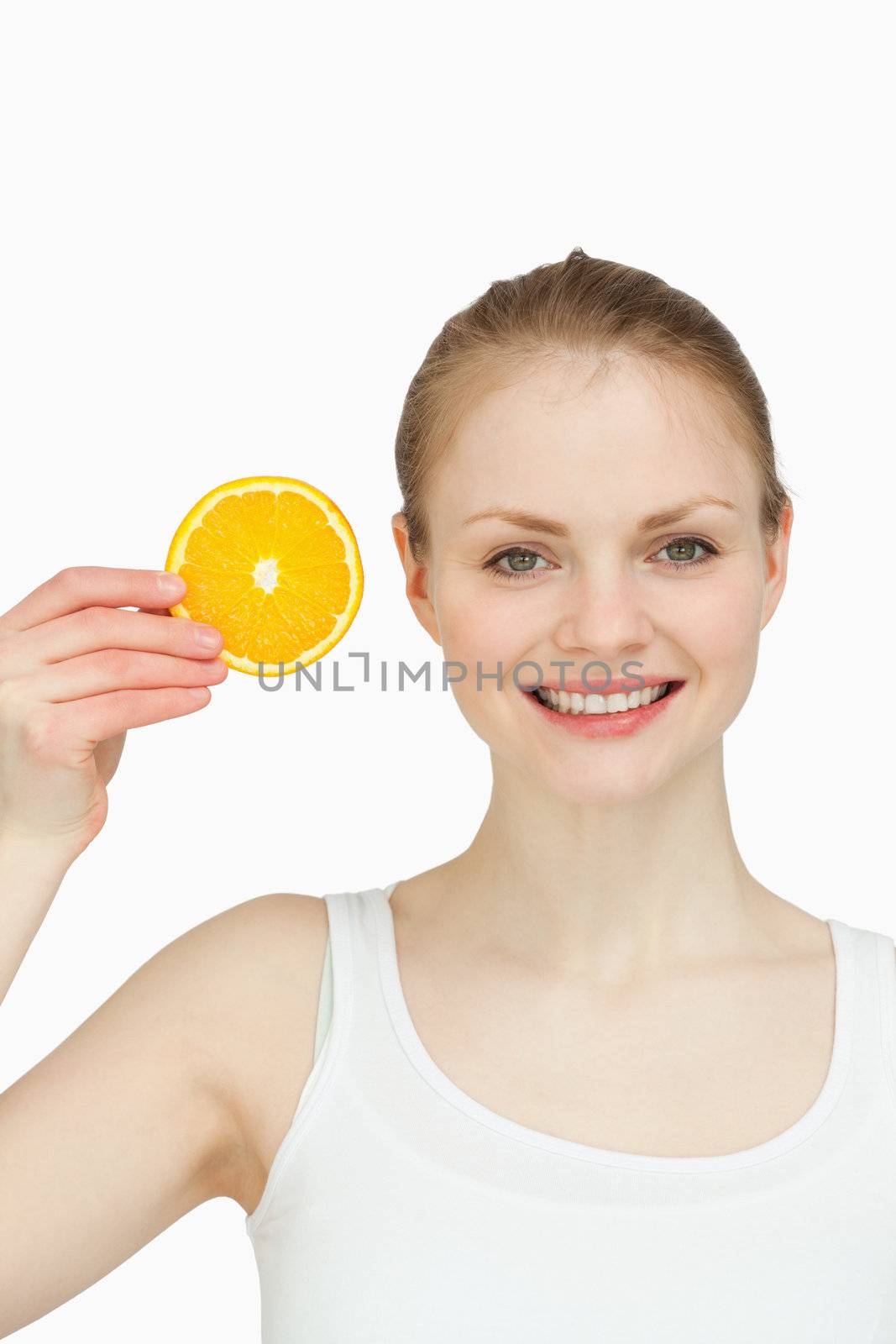 Cheerful woman holding an orange slice against white background