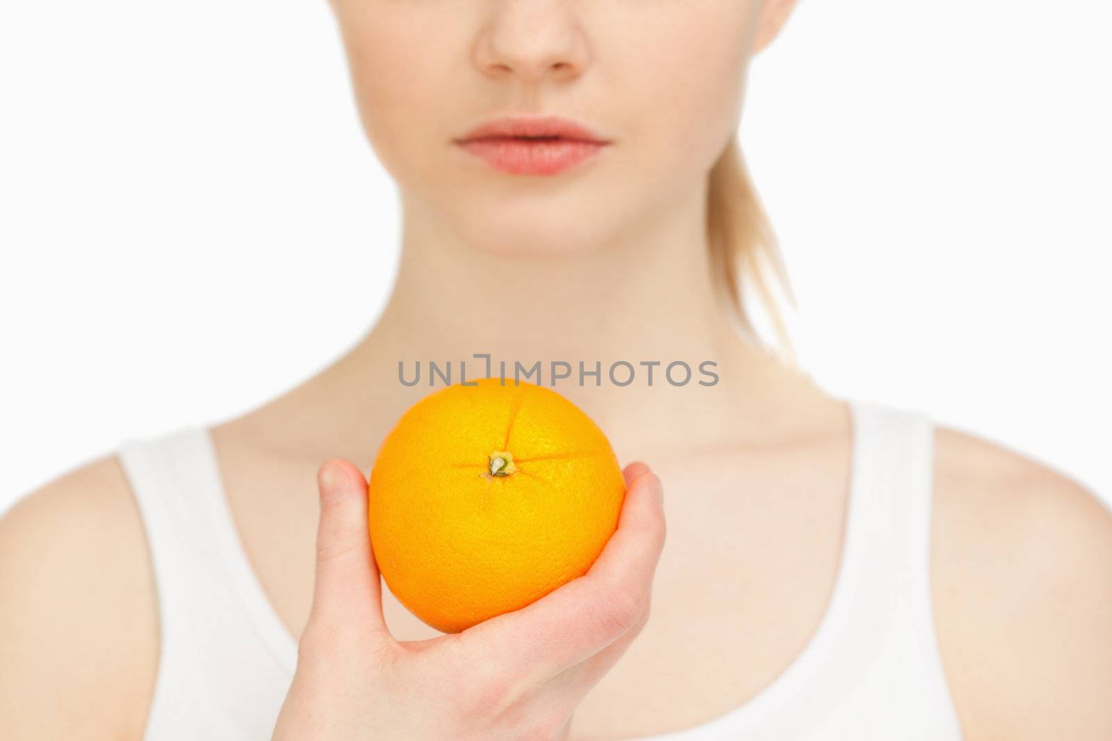 Woman holding an orange against white background