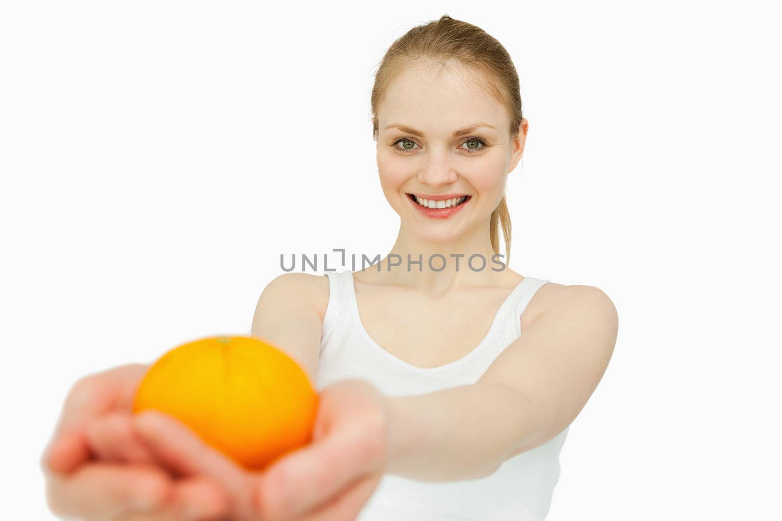 Joyful woman presenting a tangerine against white background