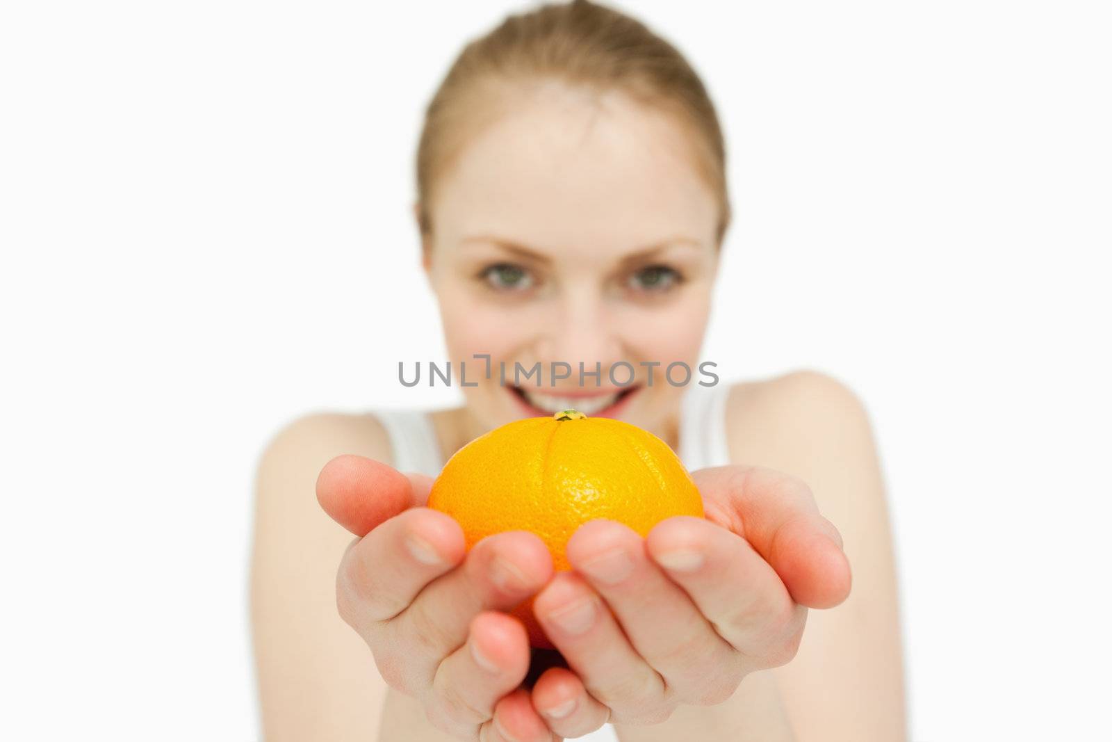 Young woman holding a tangerine against white background