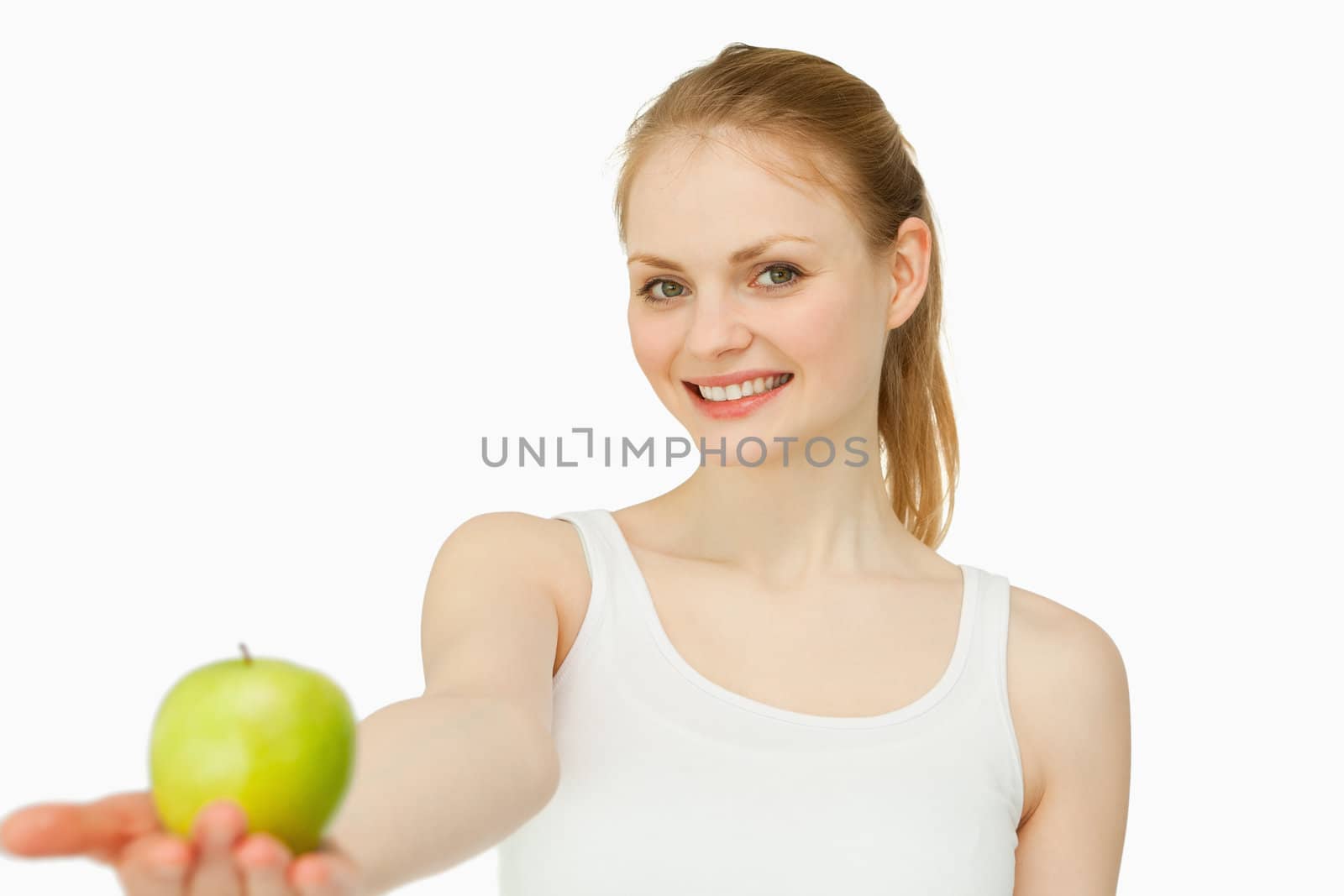 Woman smiling while holding an apple against white background