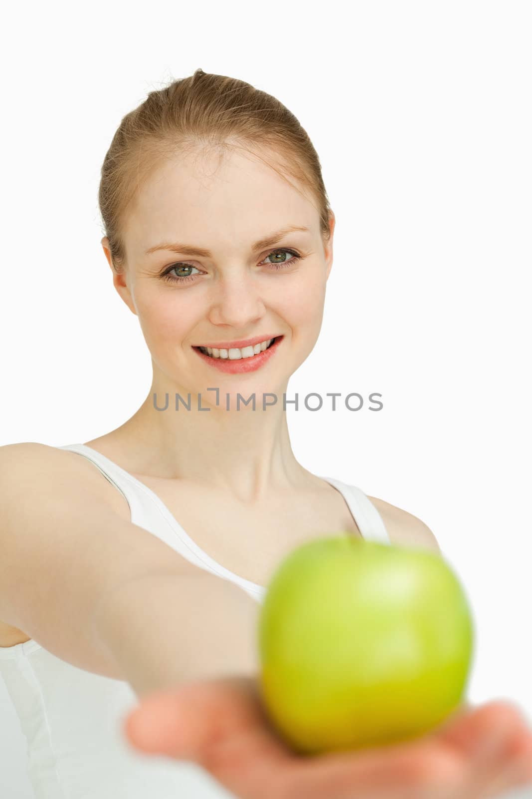 Young woman presenting an apple against white background