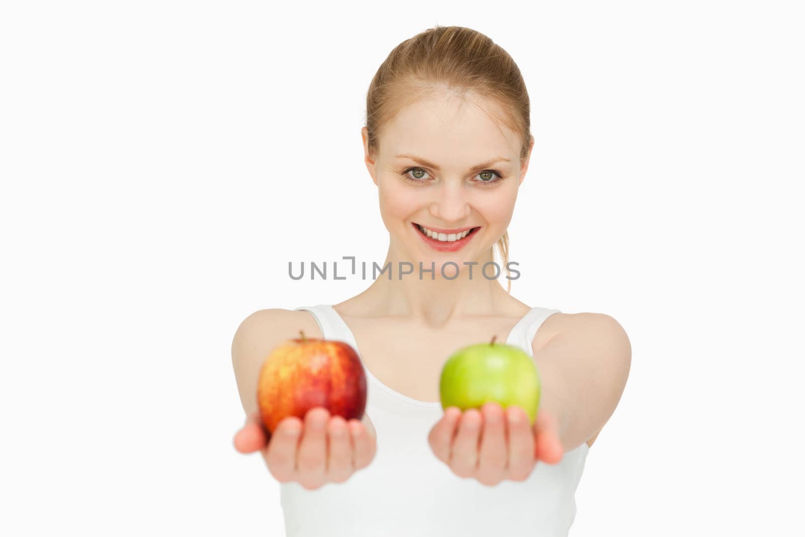 Smiling woman presenting two apples against white background