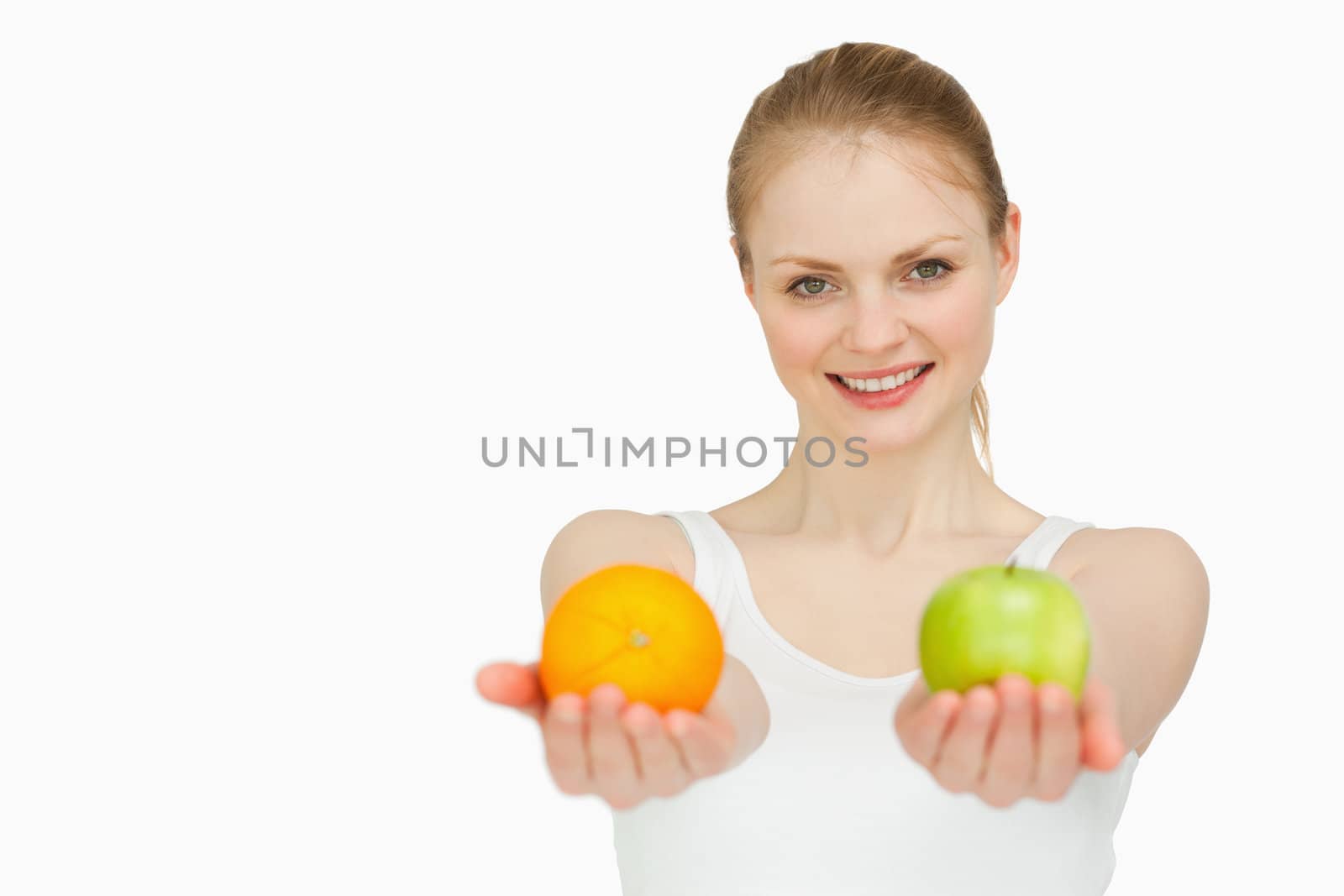 Young woman smiling while presenting fruits against white background