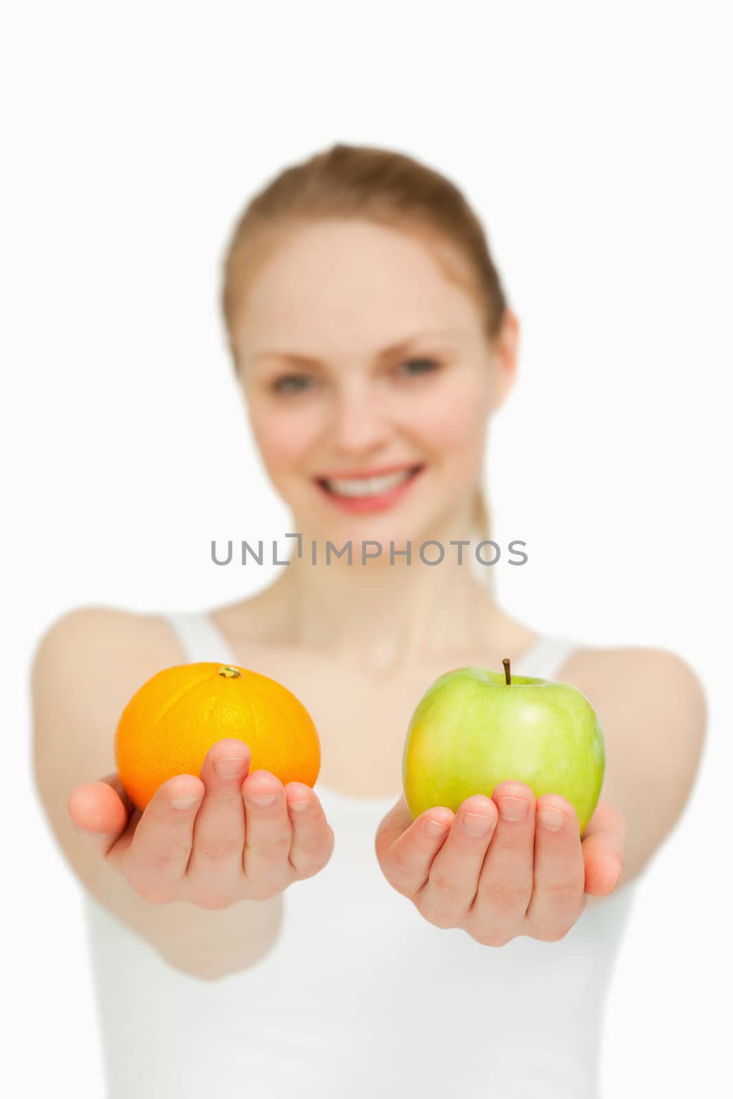 Close up of a young woman presenting fruits against white background