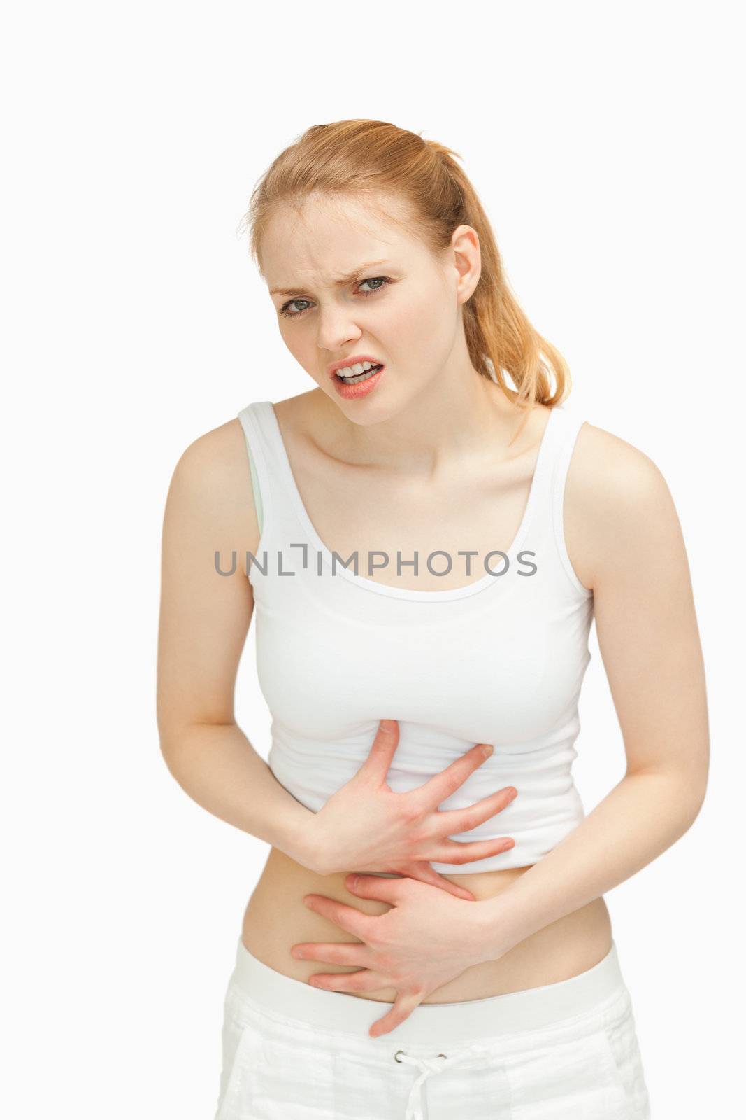 Woman placing her hands on her painful stomach against white background