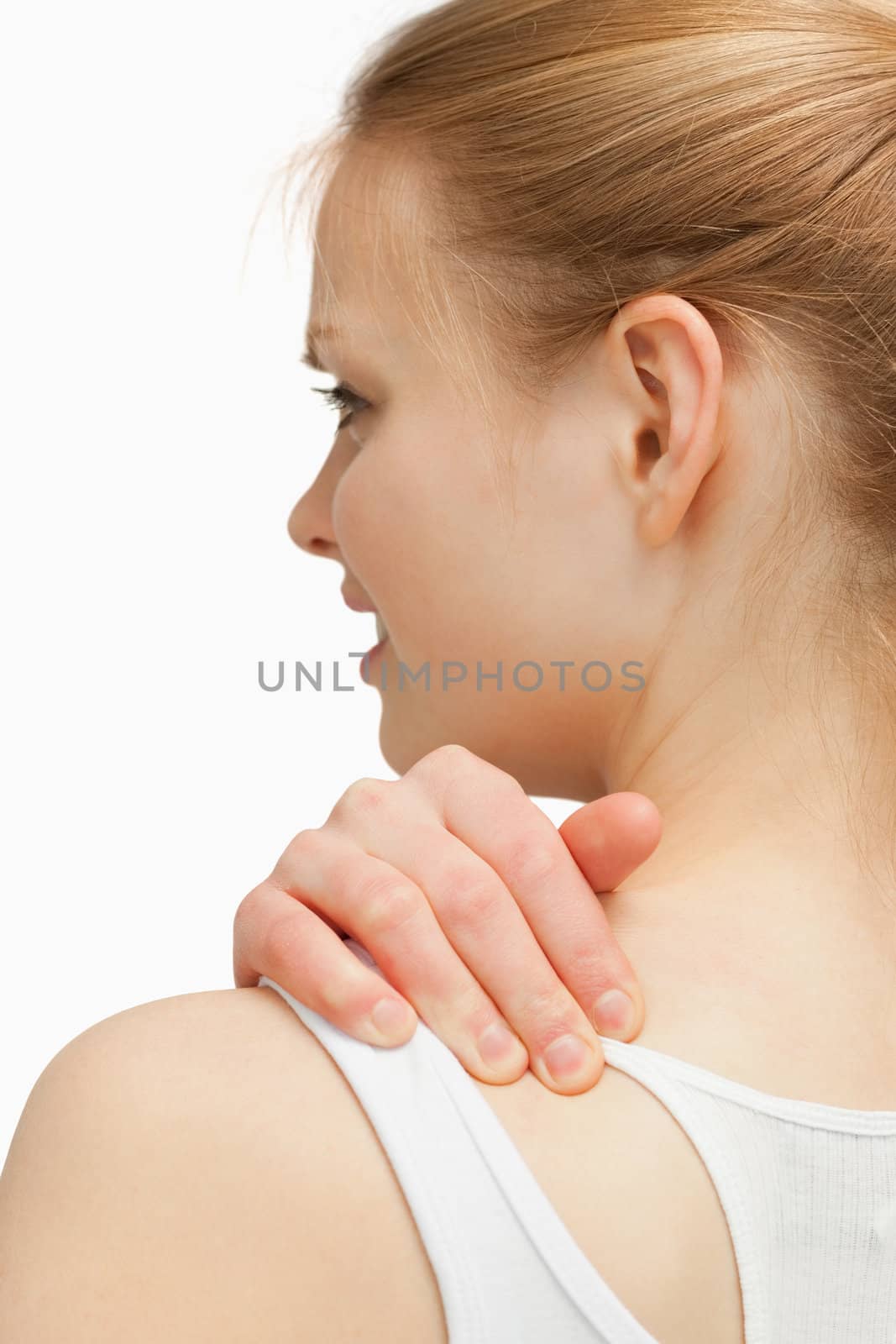 Young woman massaging her nape against white background 