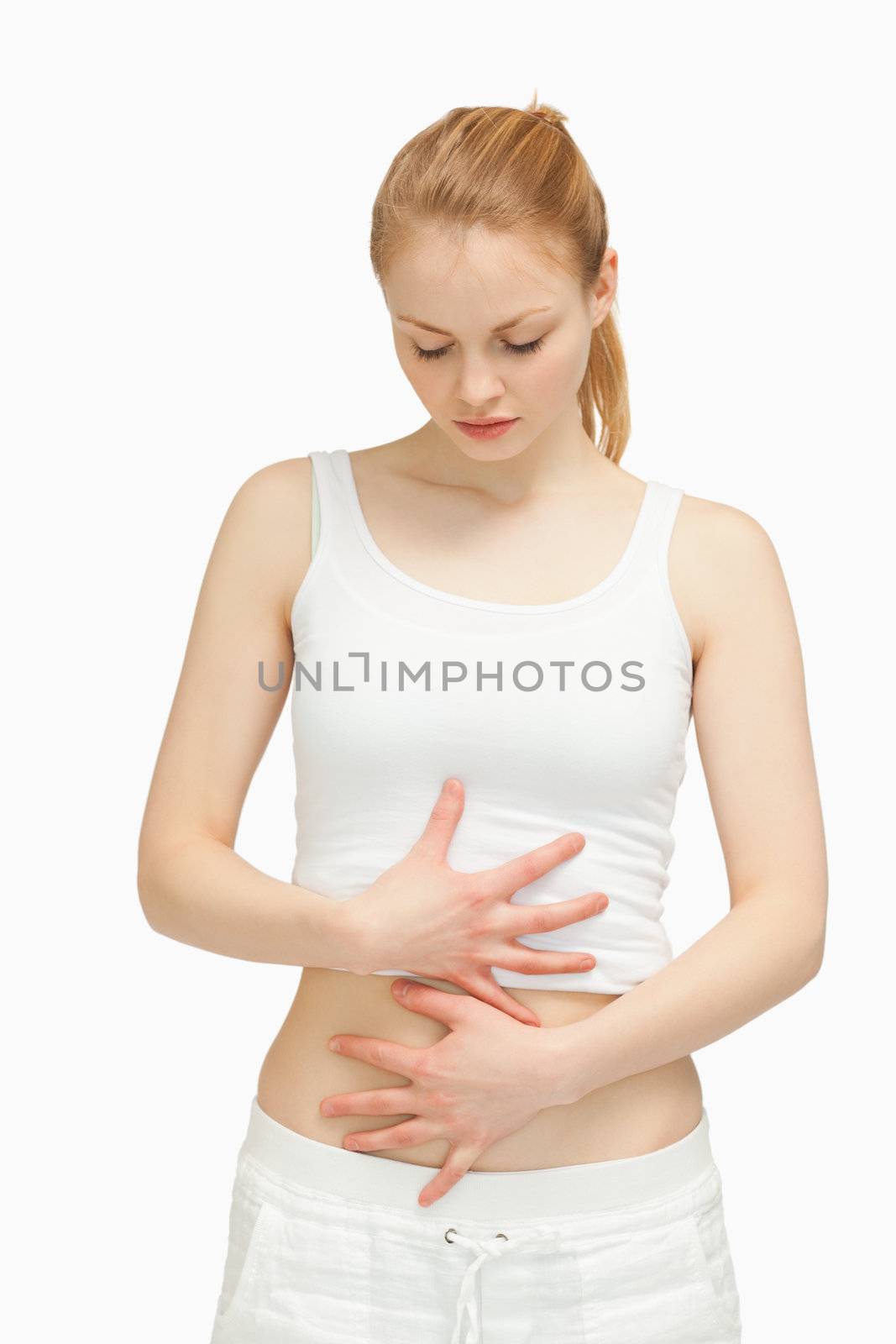 Woman placing her hands on her stomach against white background