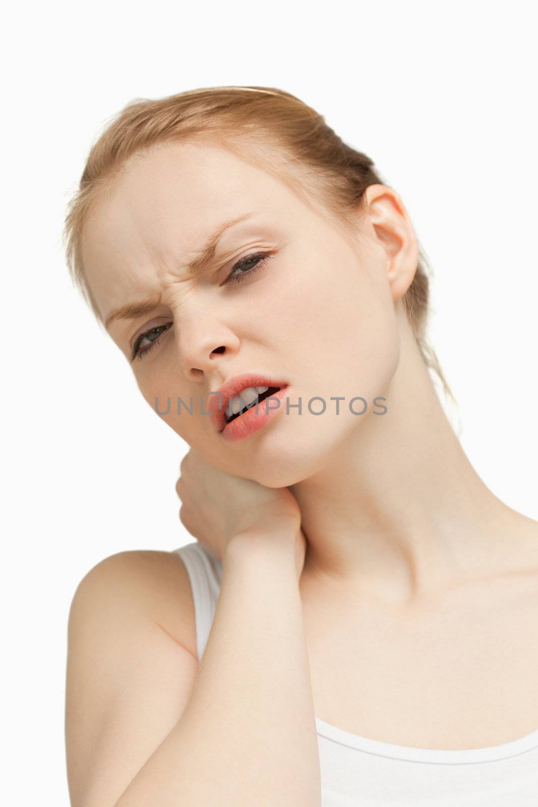 Young woman massaging her painful back against white background