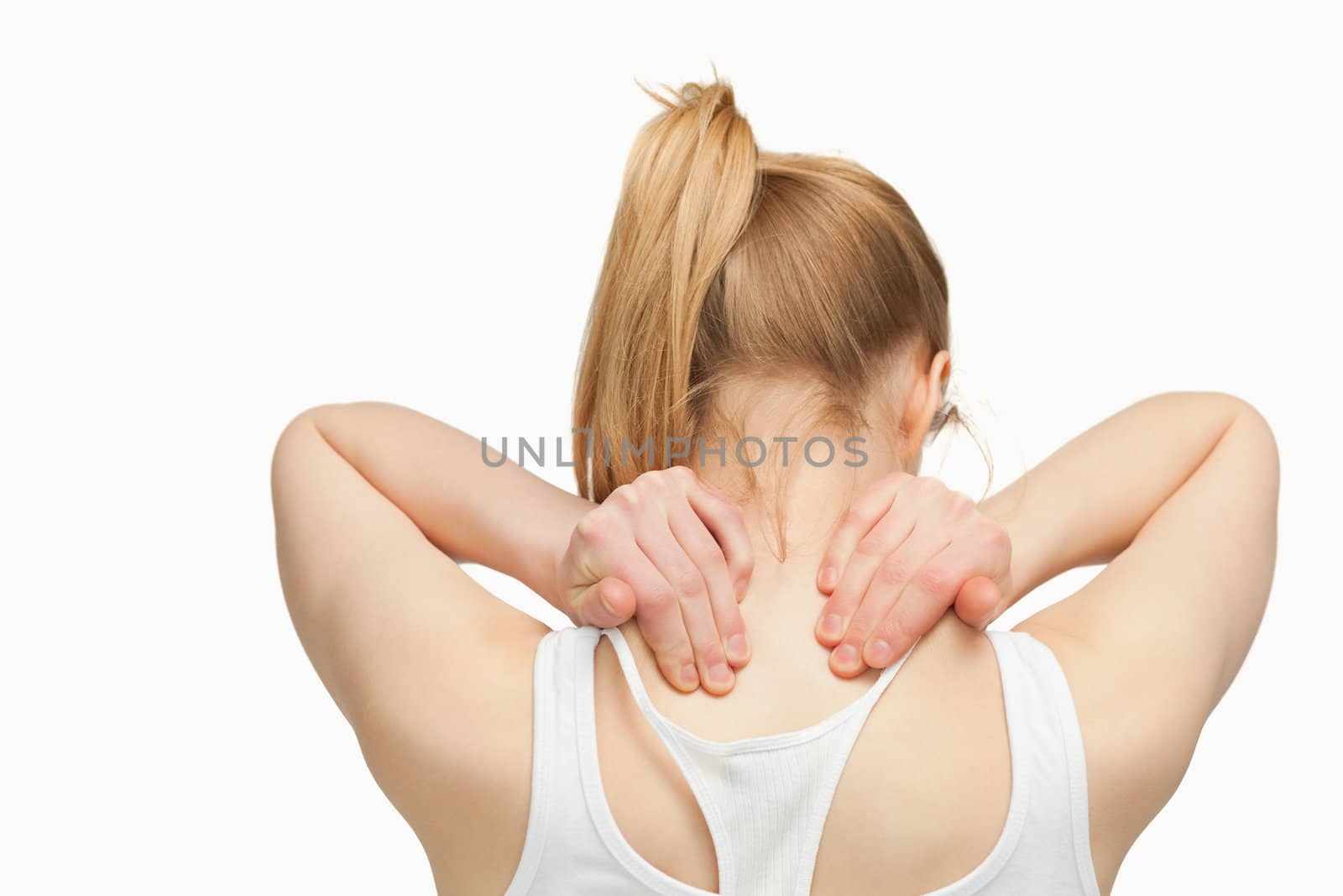 Woman massaging her nape with her hands against white background