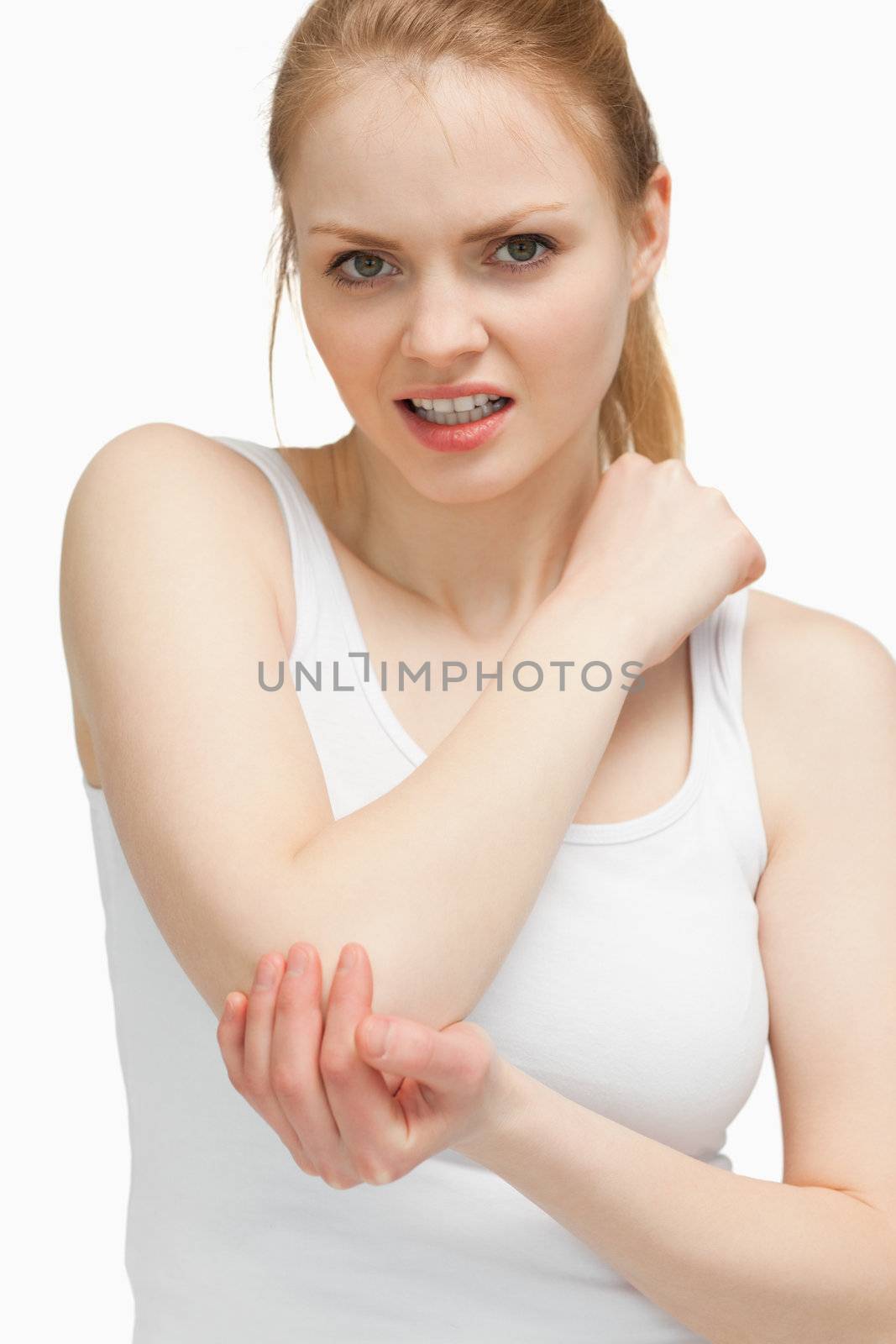 Blonde woman touching her painful elbow against white background