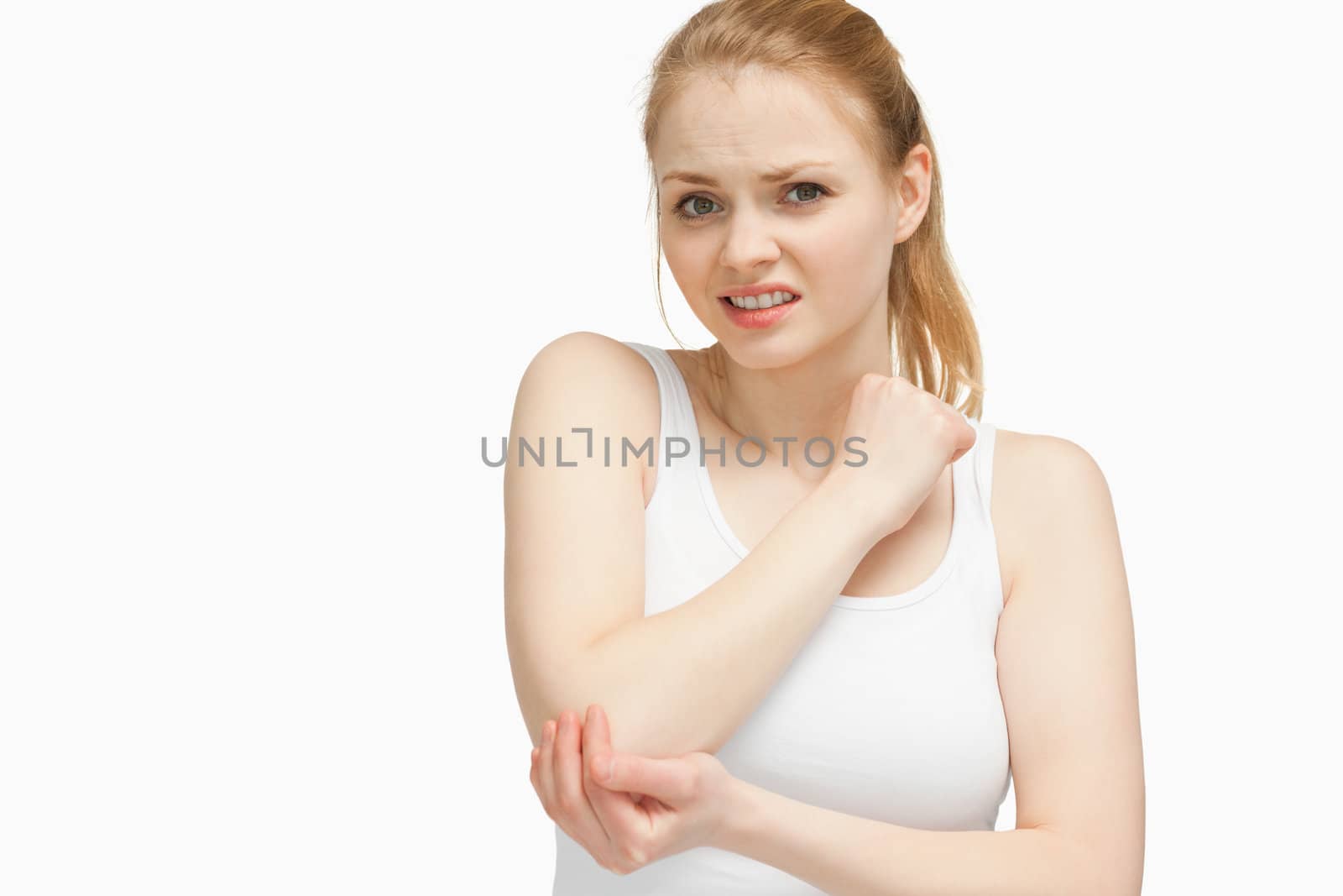 Fair-haired woman touching her elbow