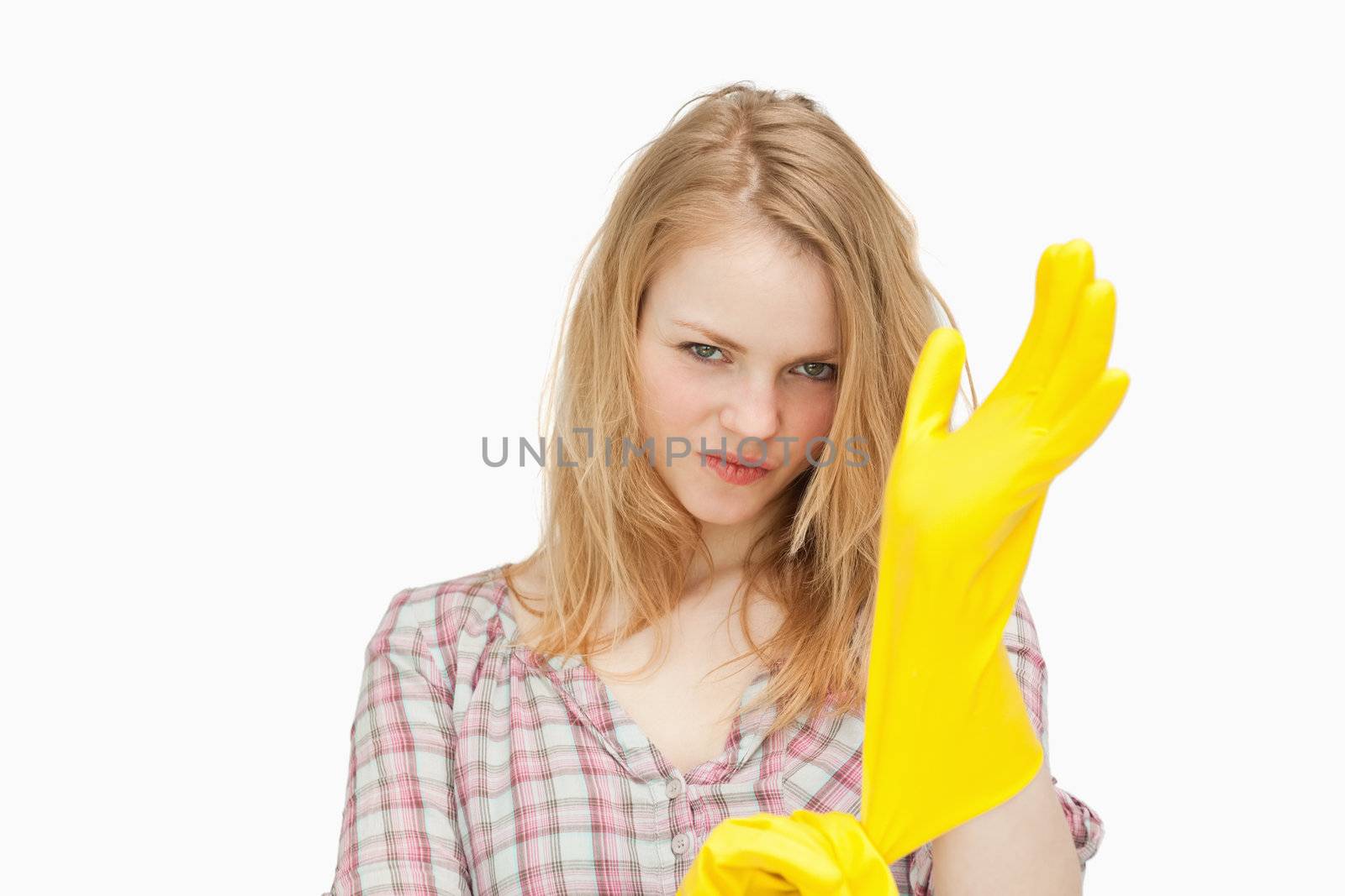 Woman frowning while putting gloves against white background