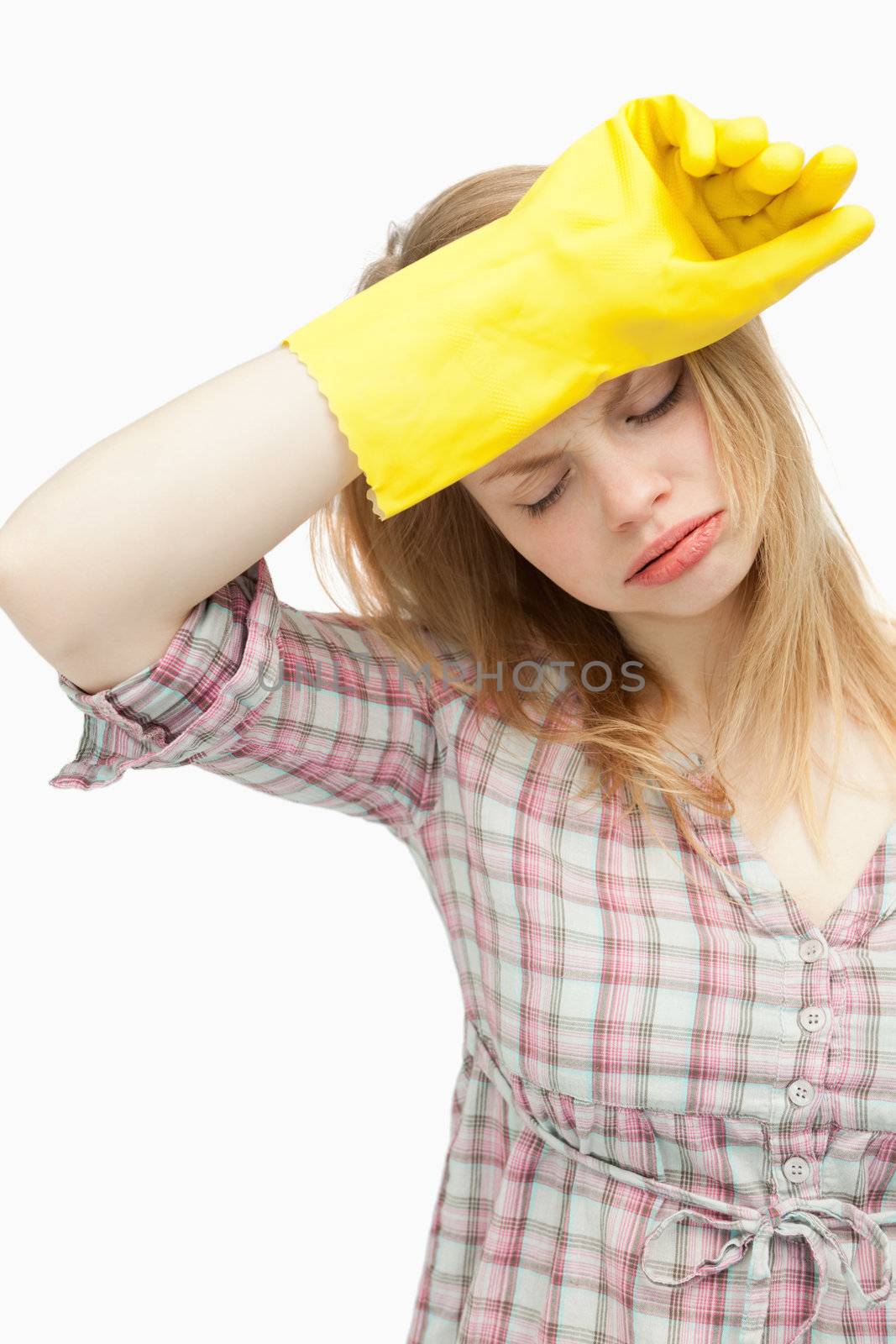 Tired woman wearing cleaning cloves against white background