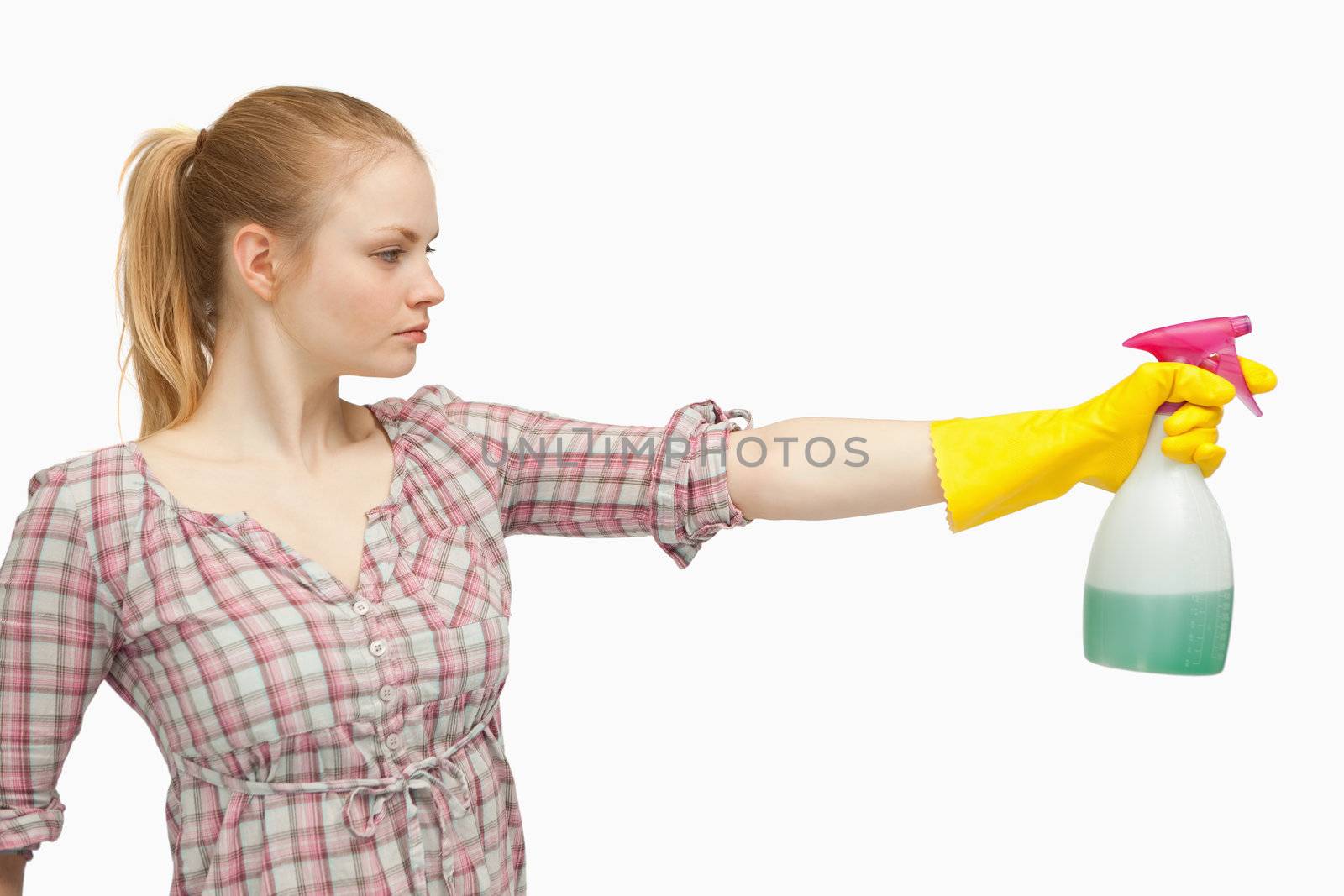 Joyful woman holding a spray bottle against white background