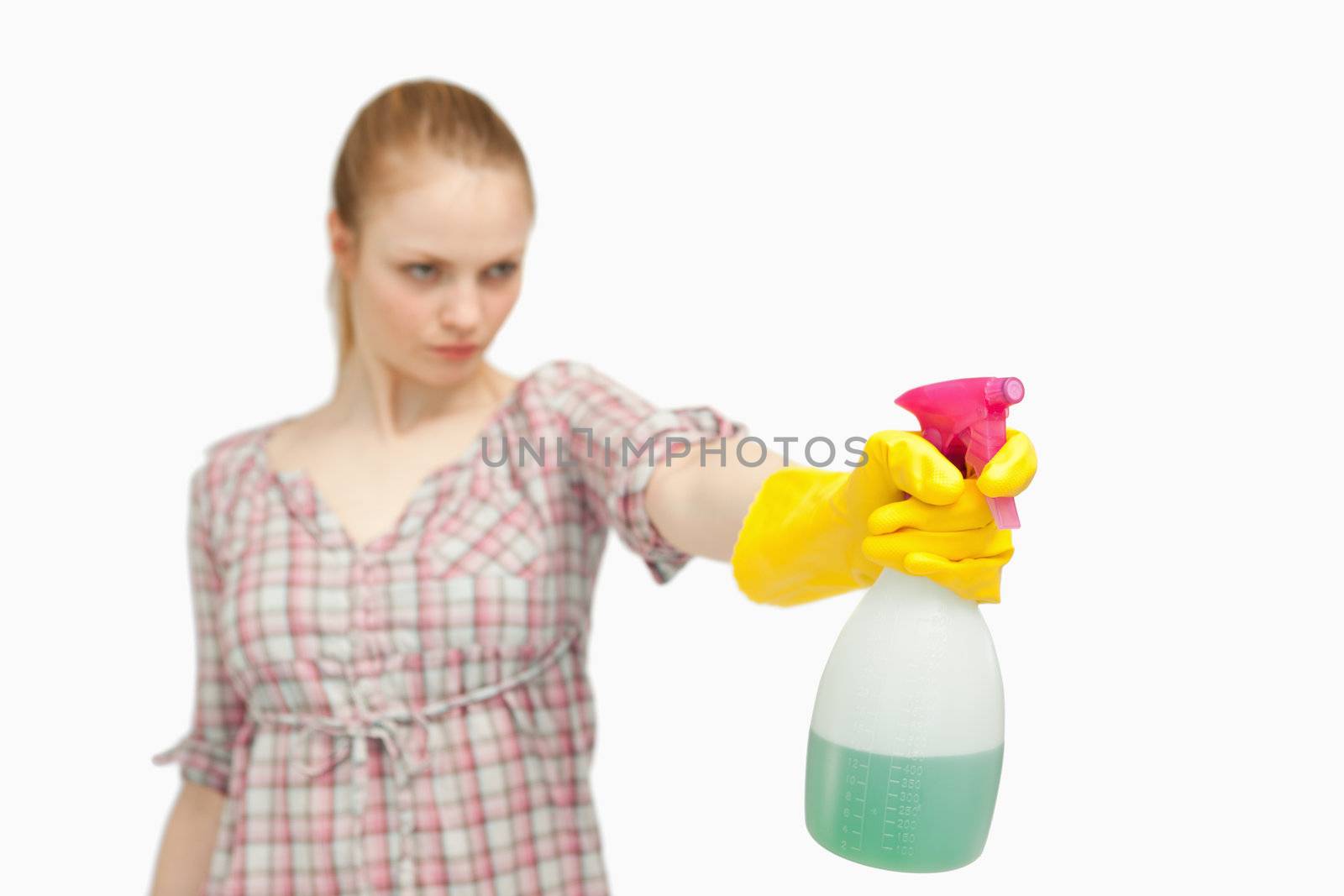 Serious woman holding a spray bottle against white background