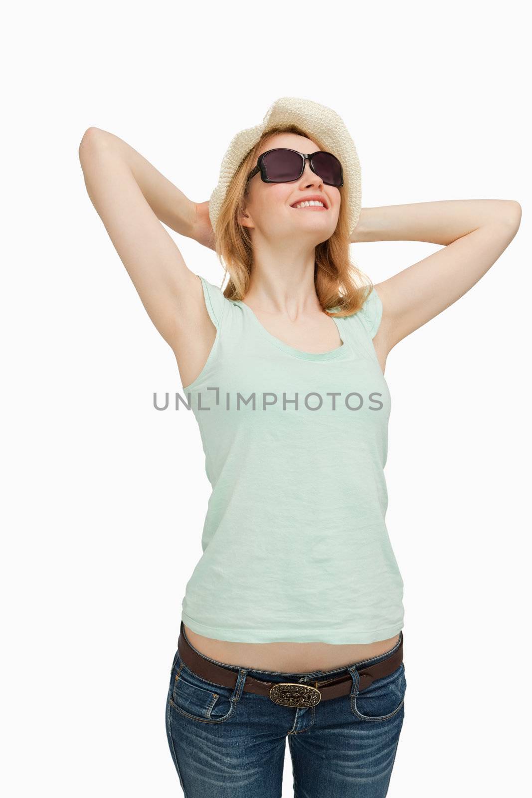 Woman smiling while wearing a summer hat against white background