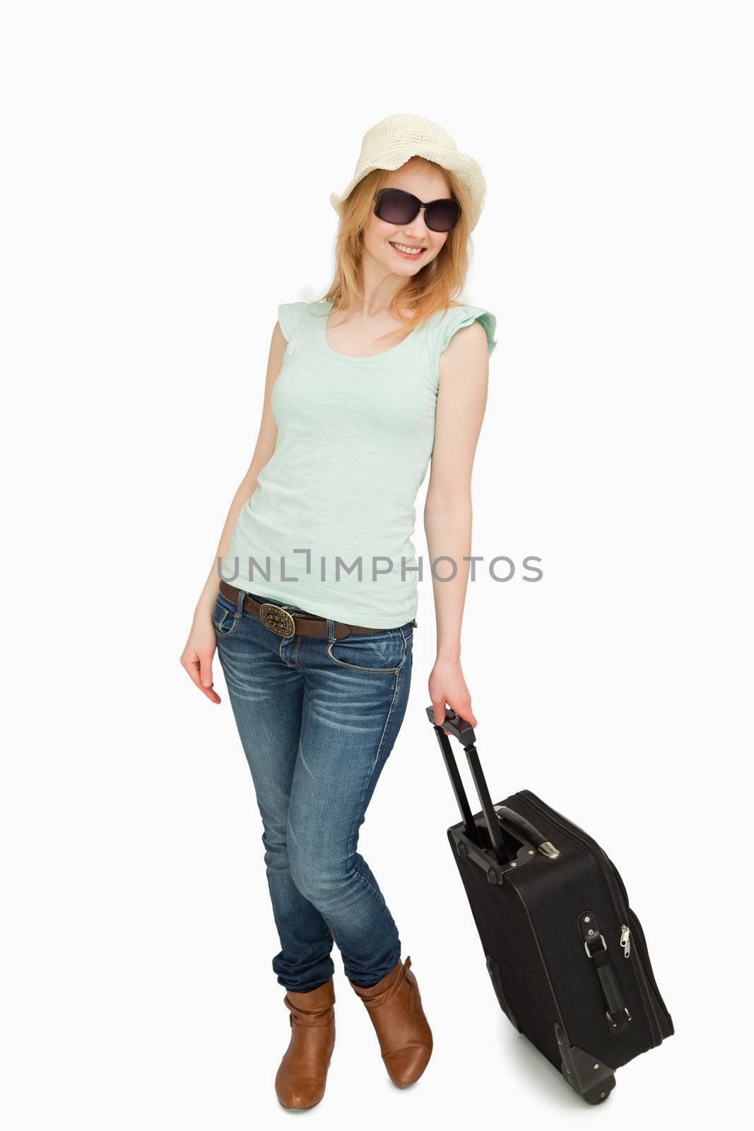 Woman holding a suitcase while standing against white background