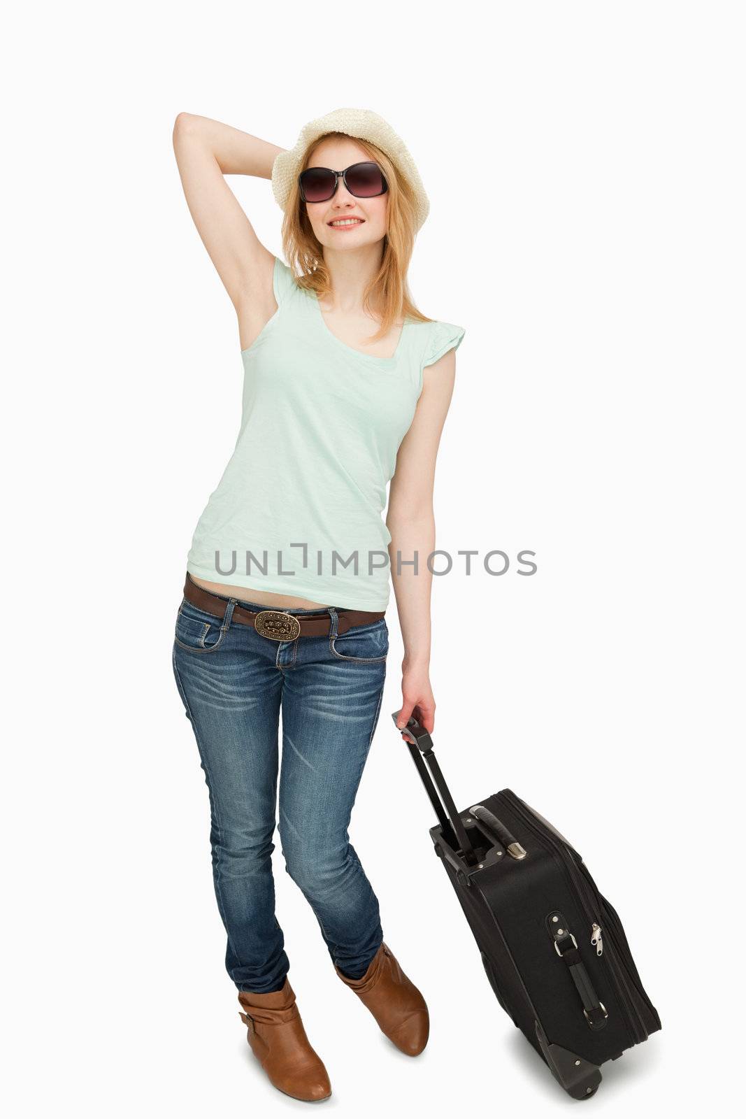 Young woman holding a suitcase while standing against white background