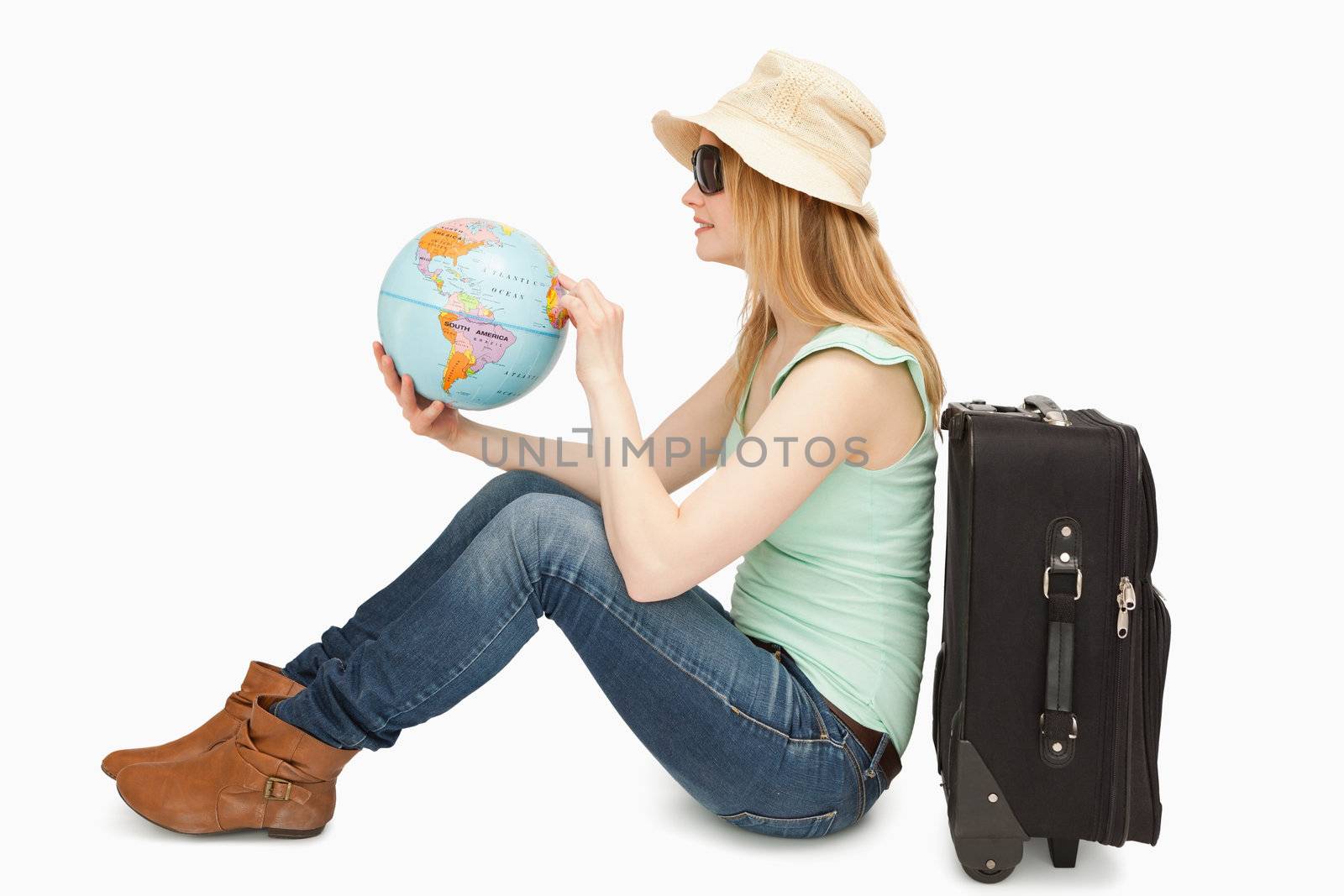 Woman holding a world globe while sitting against white background