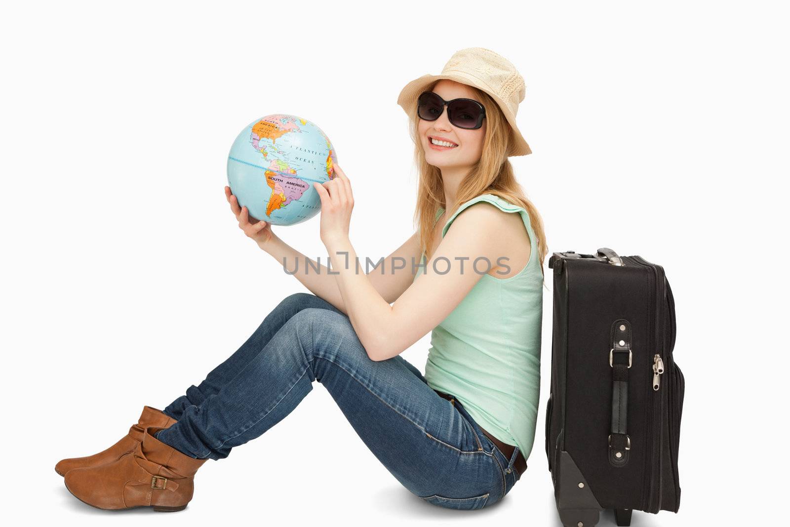 Woman holding a world globe while smiling against white background
