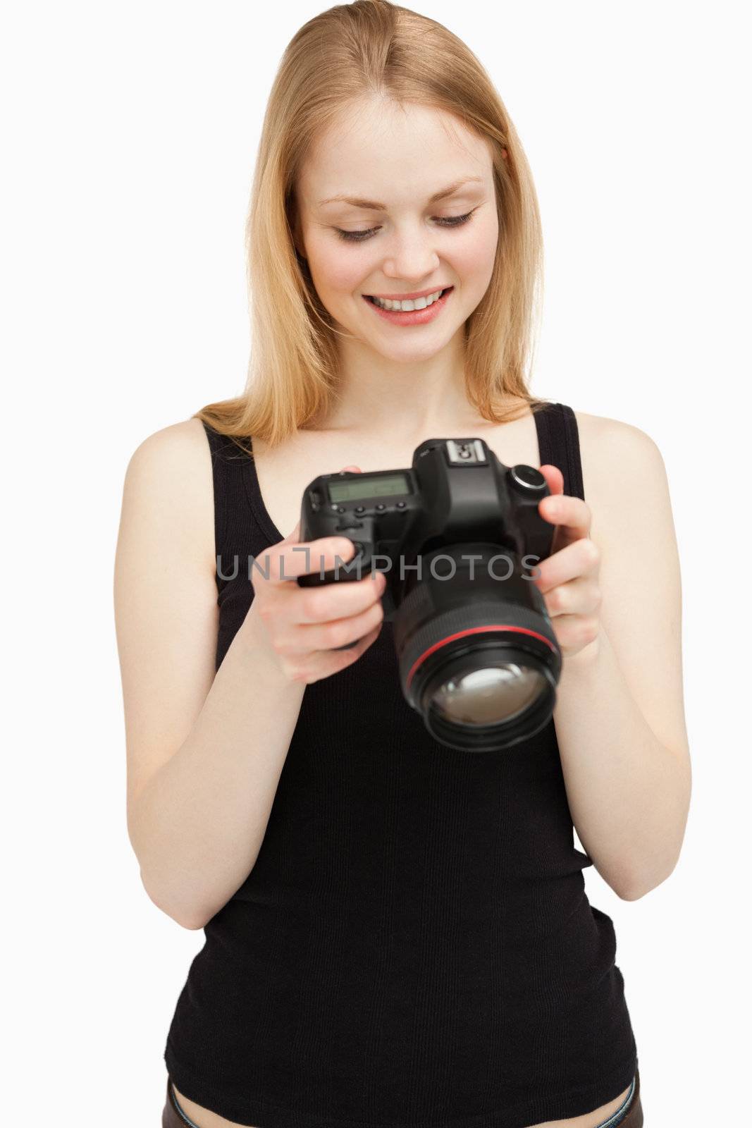 woman looking at her camera wile smiling against white background