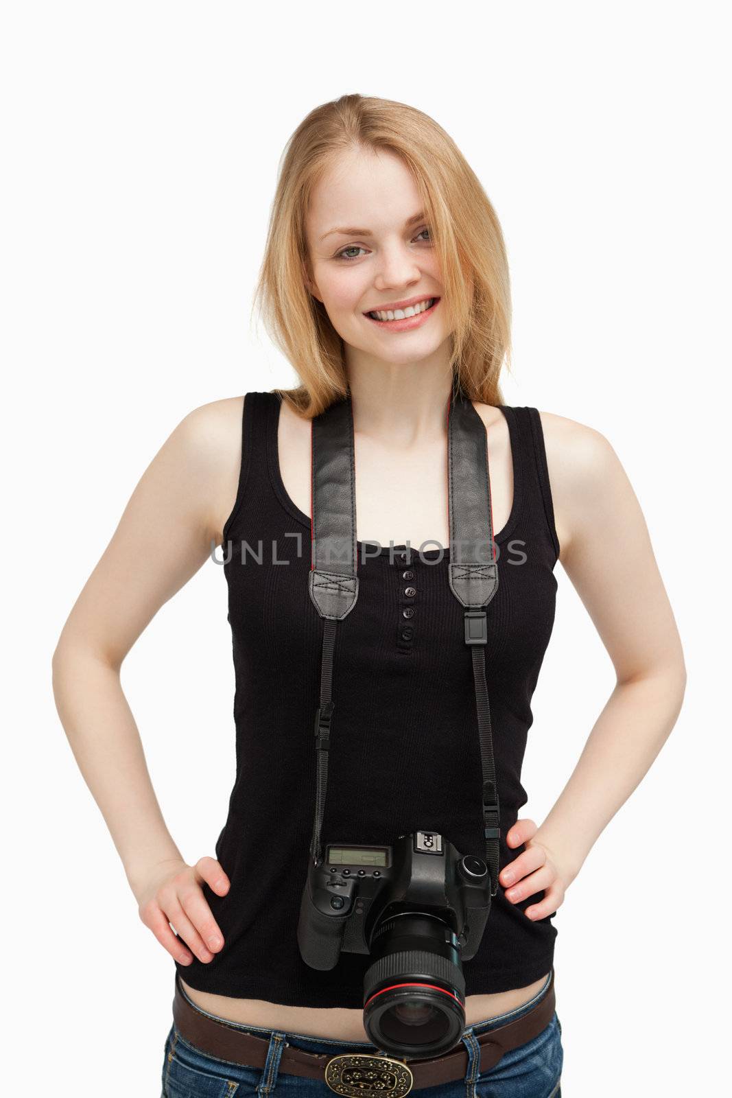 Joyful woman carrying a camera against white background