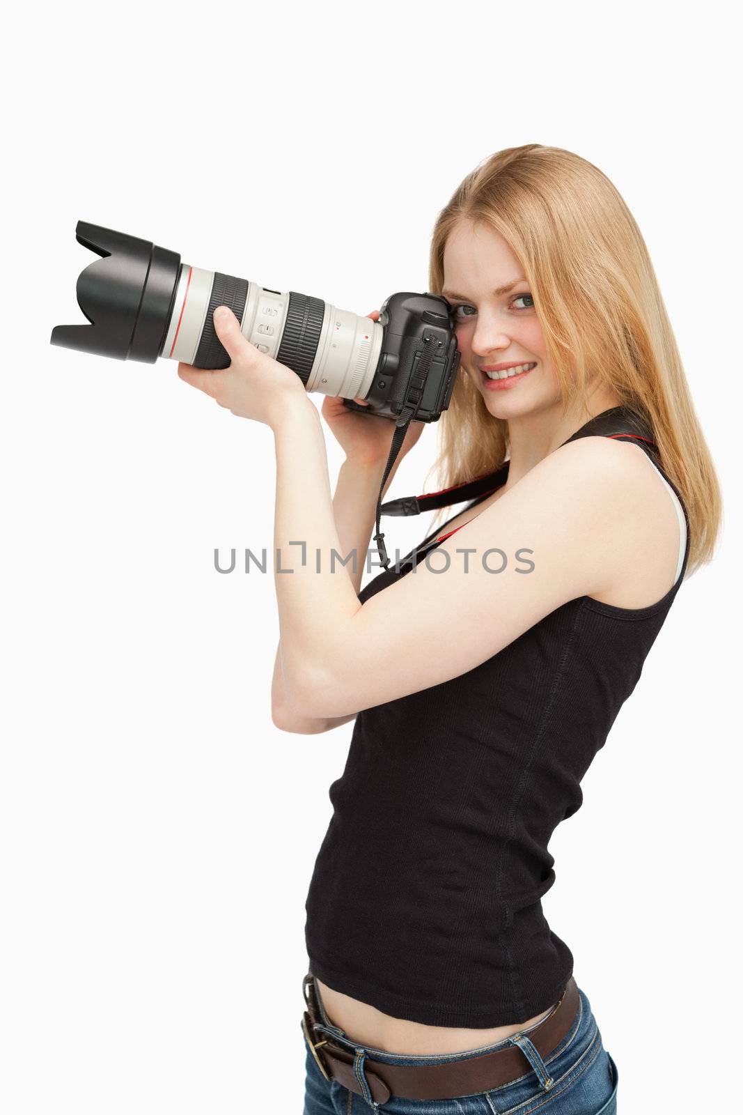 Joyful woman holding a SLR camera against white background