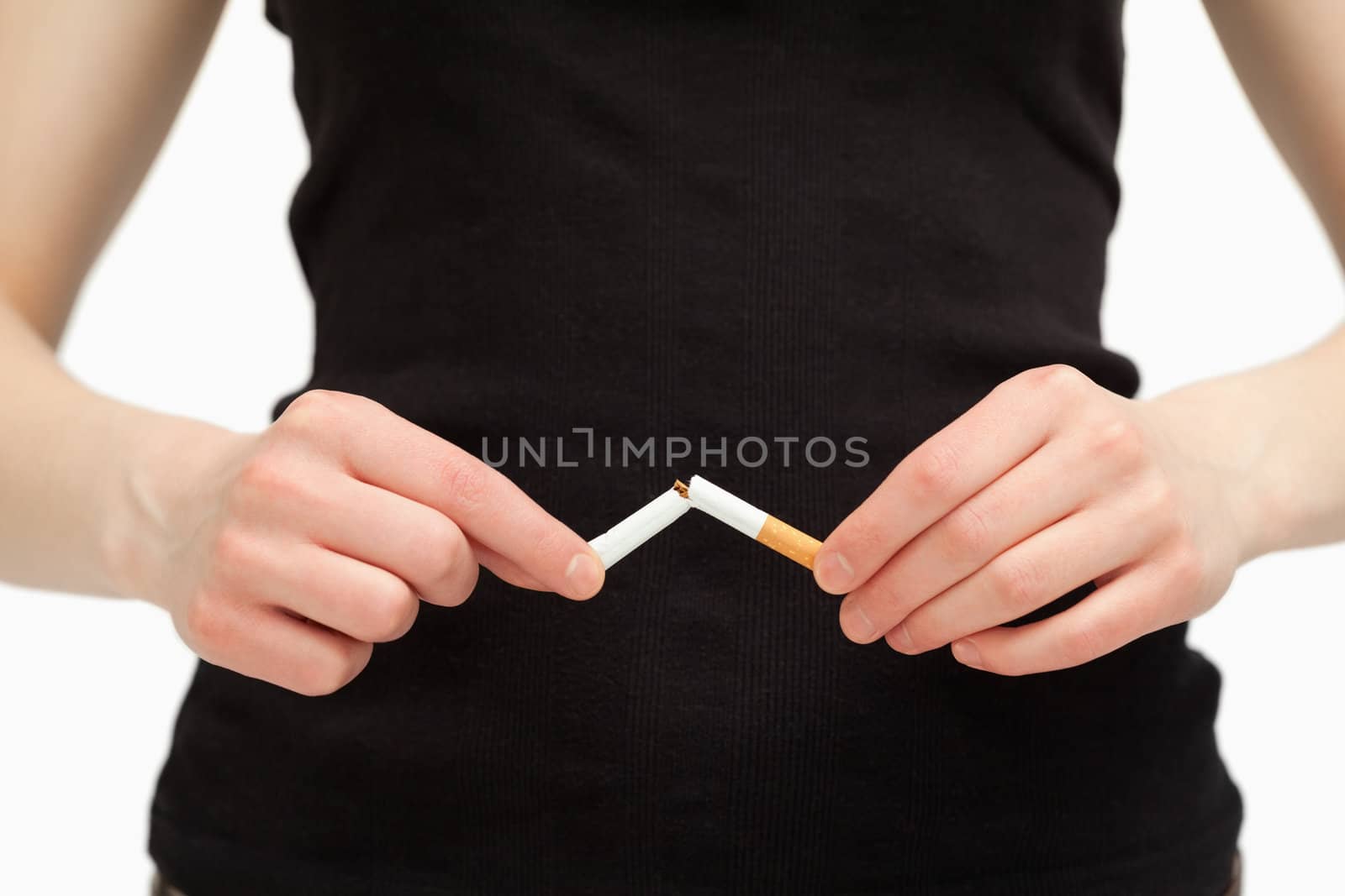 Close up of hands breaking a cigarette against white background