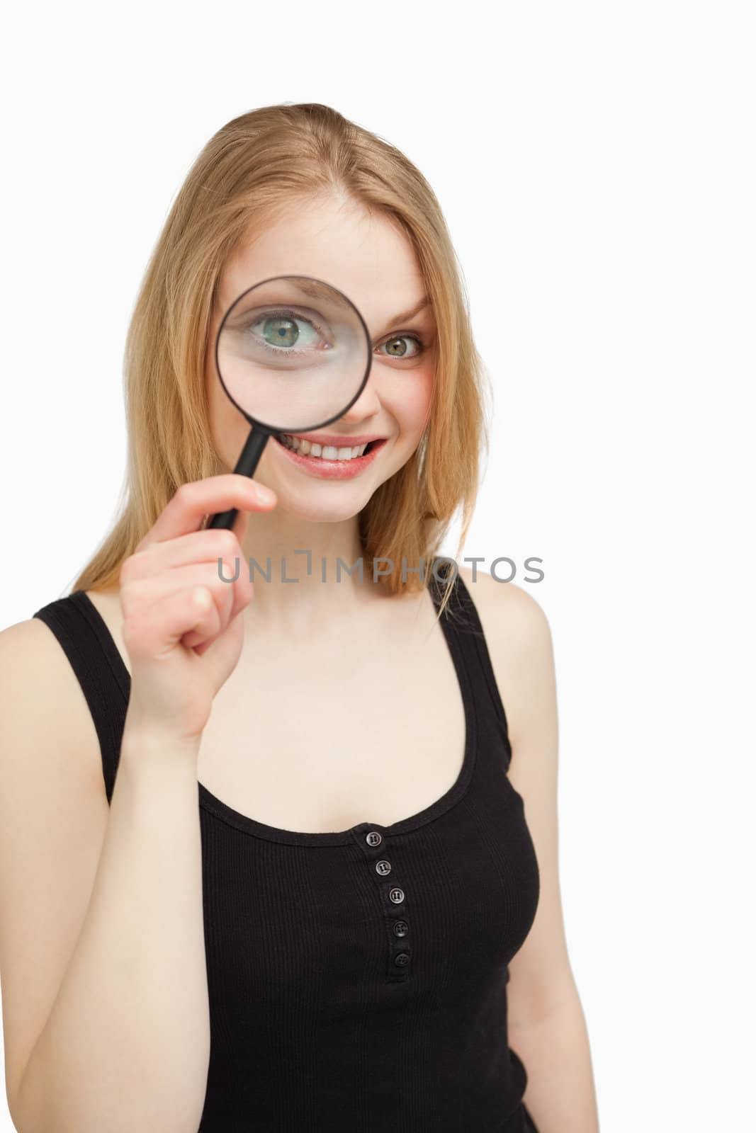 Smiling woman using a magnifying glass against white background