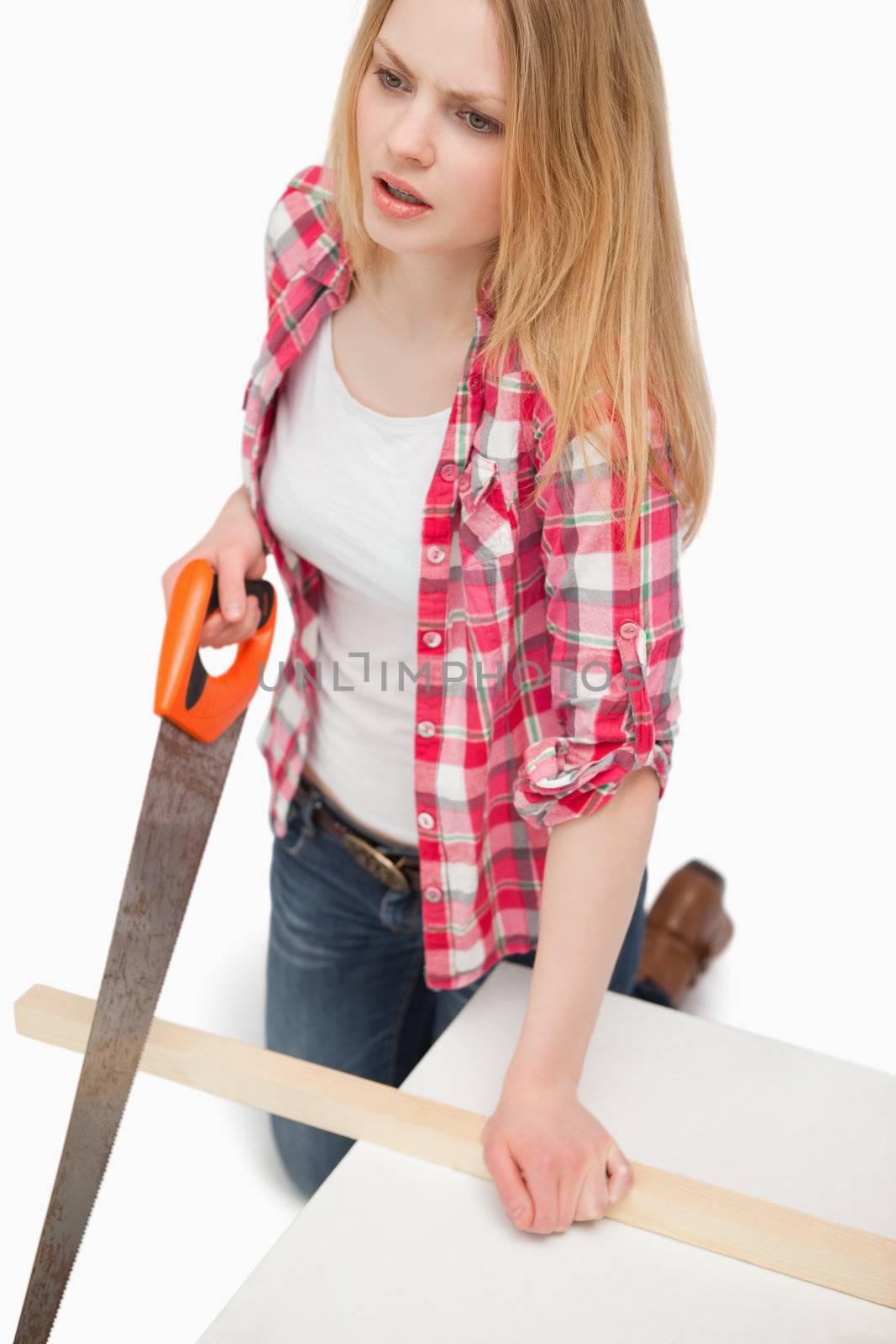 Woman using a wood saw against white background