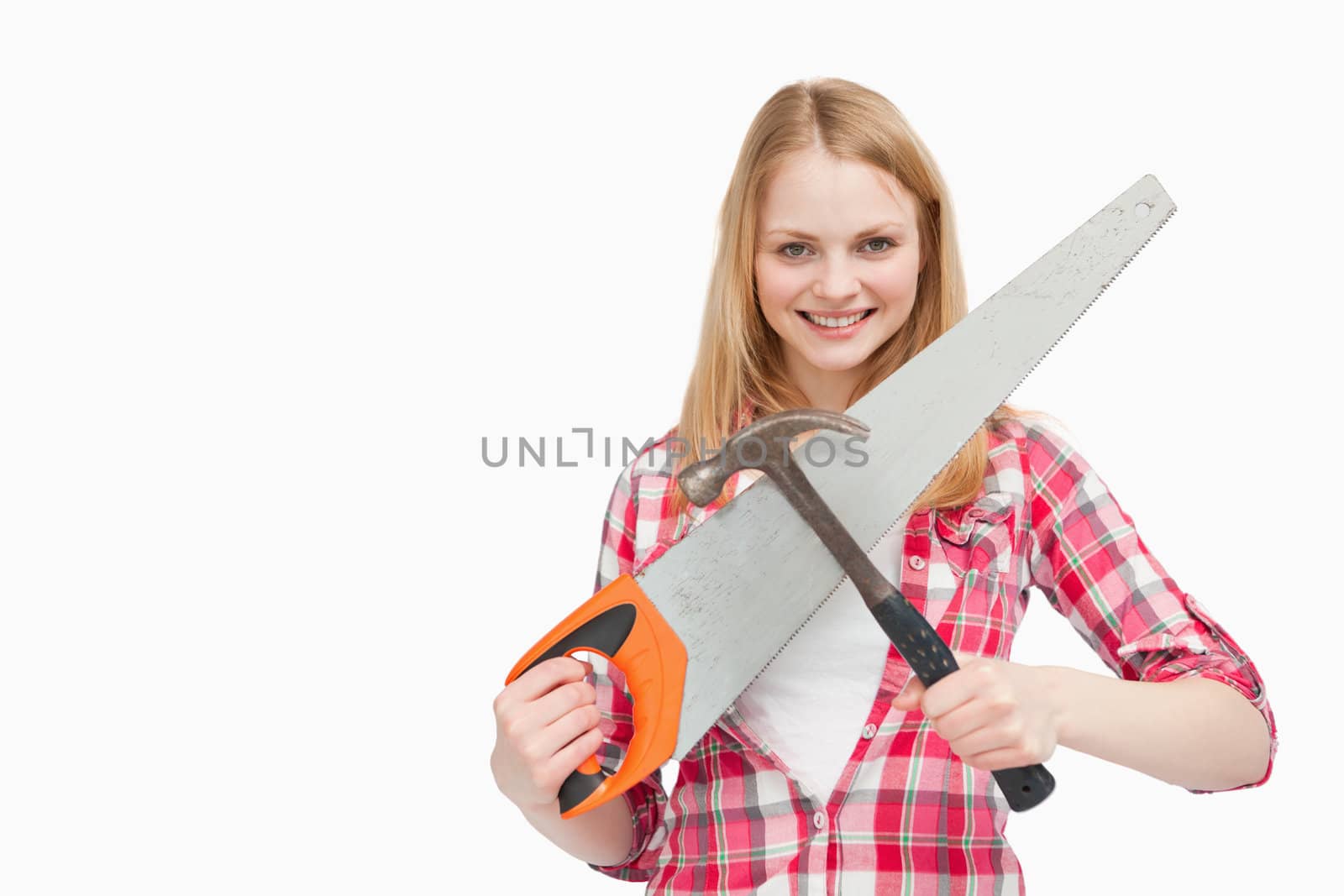 Woman holding a hammer and a saw against white background