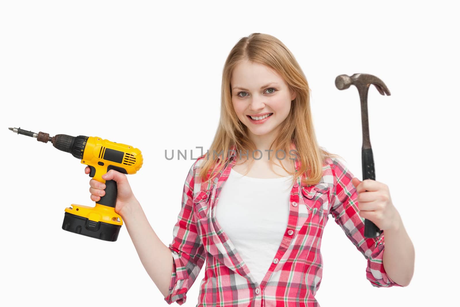 Smiling woman holding tools against white background
