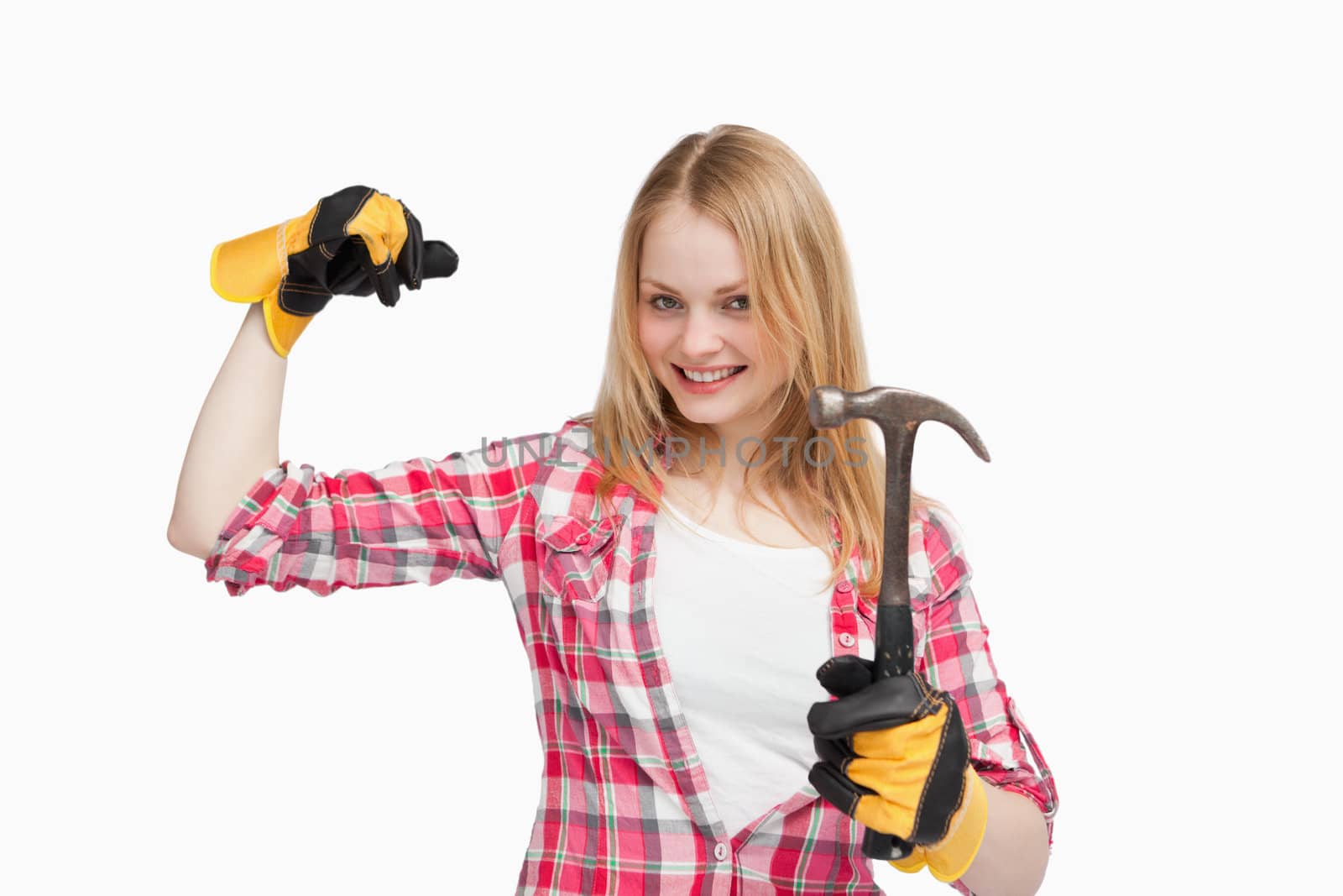 Joyful woman holding a hammer against white background