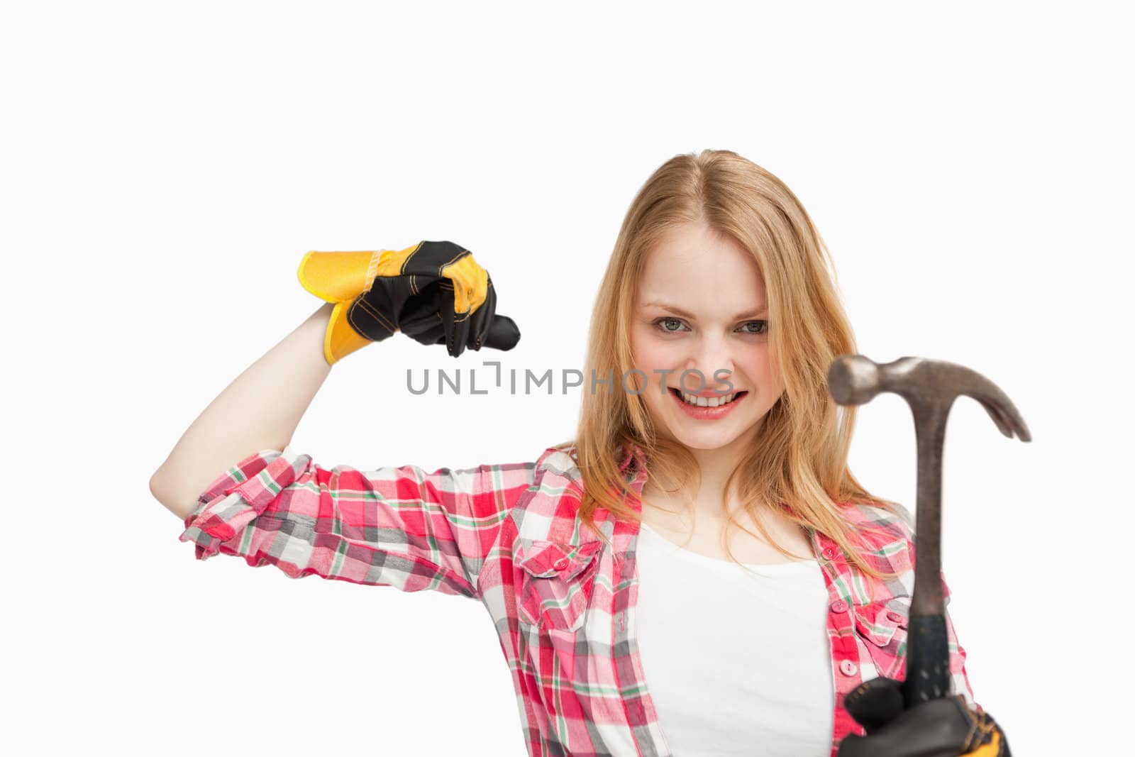 Woman smiling while holding a hammer against white background