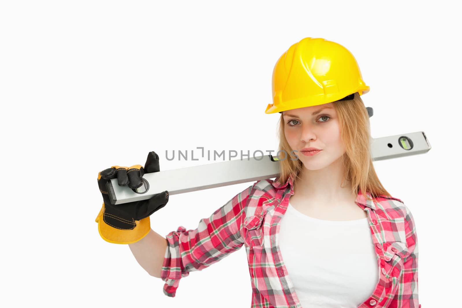 Serious woman holding a spirit level against white background